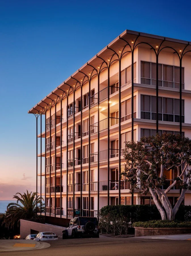 pink apartment building with arched iron details overlooking the Pacific Ocean