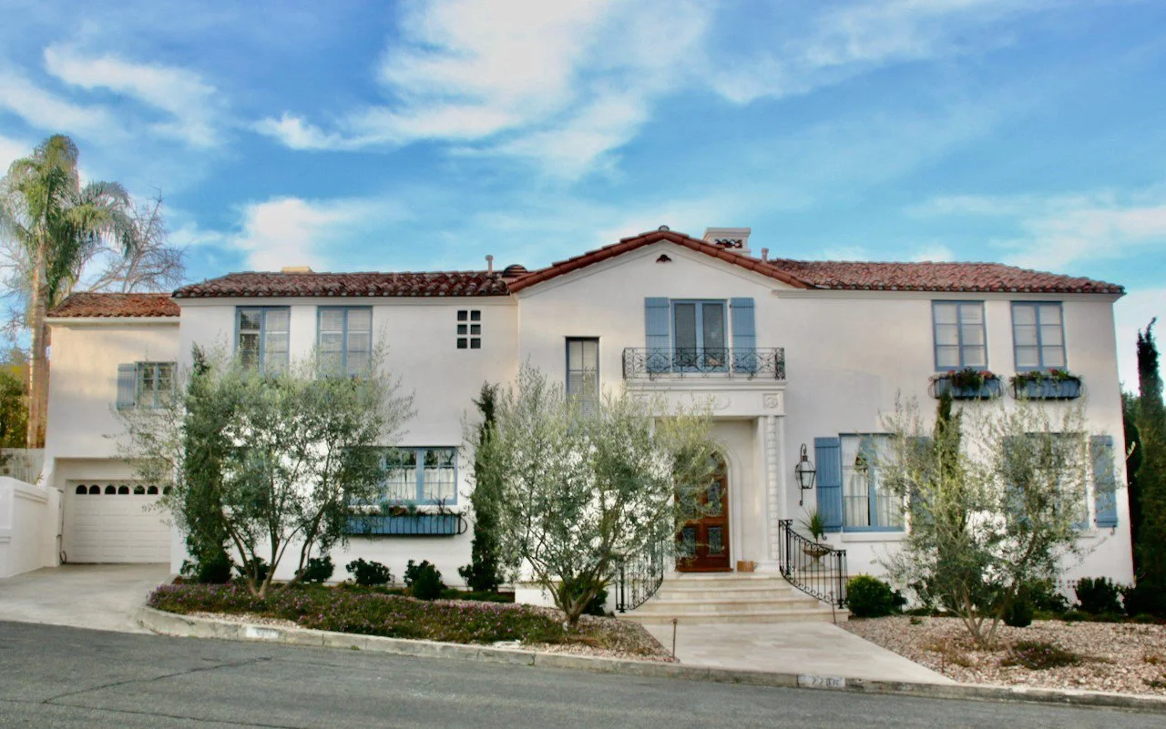 white Spanish style house with landscaping