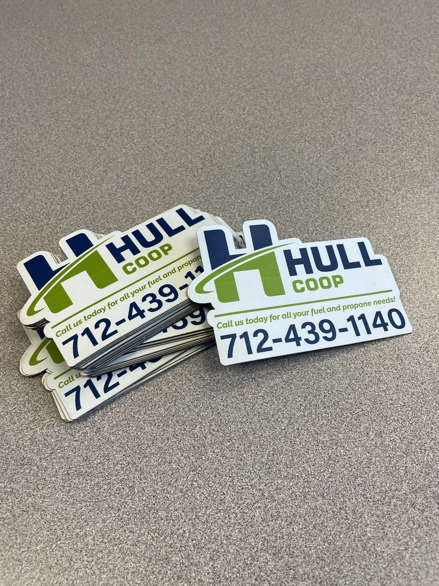 A stack of HULL COOP fuel and propane discount cards on a gray table.