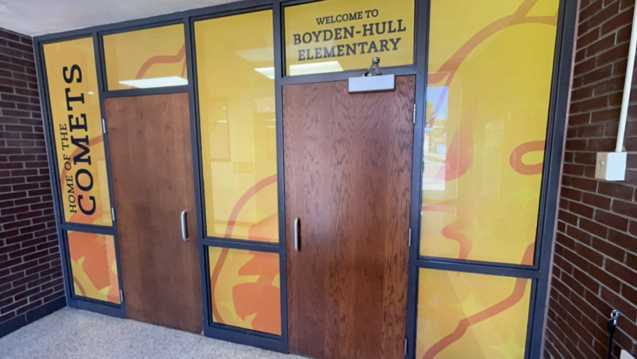 School entrance door with yellow and orange school spirit message. The door has a welcome sign to Boyden-Hull Elementary