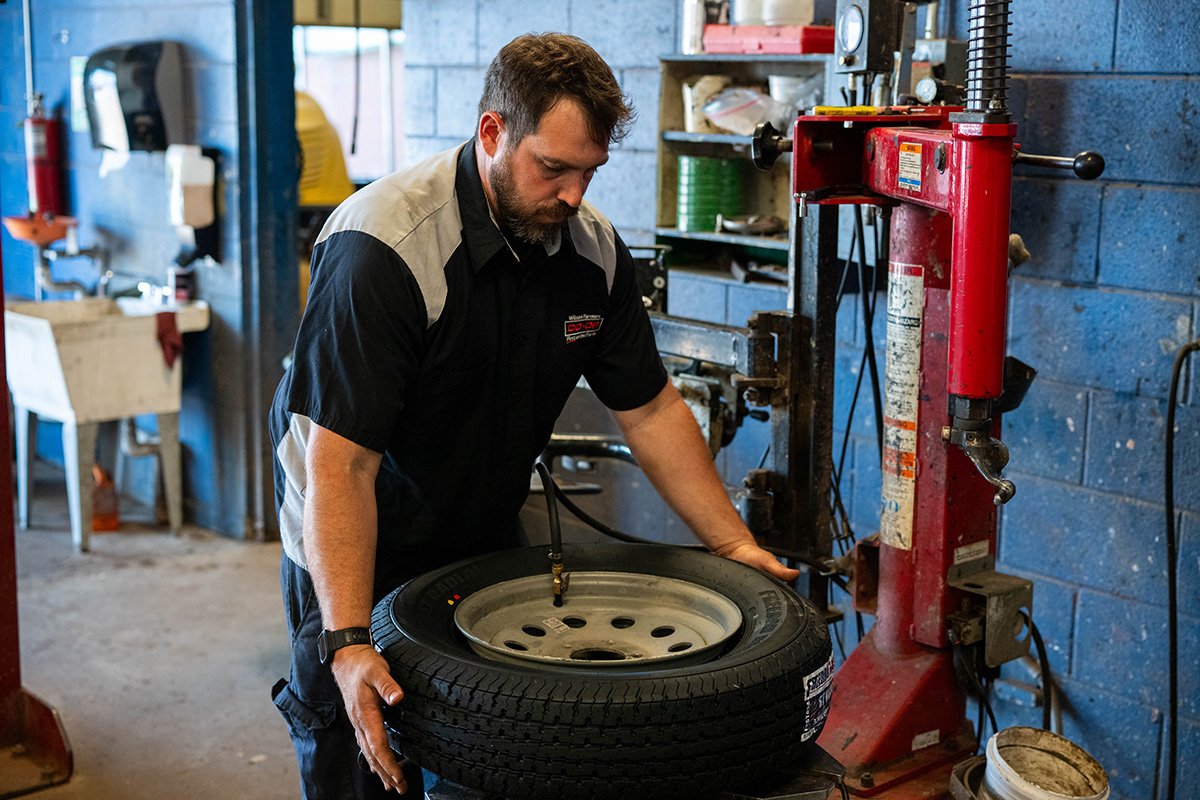 worker putting rims on tire