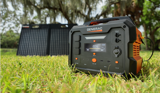 Portable solar generator with solar panel in outdoor grassy area.