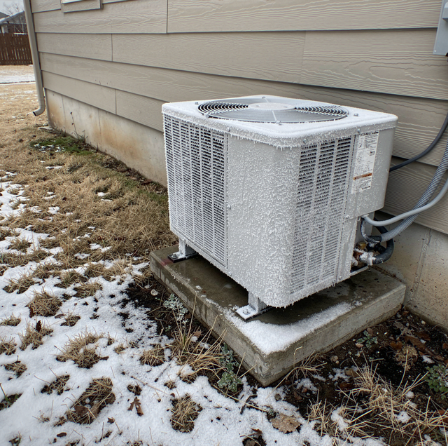 frozen outdoor heat pump unit covered in frost