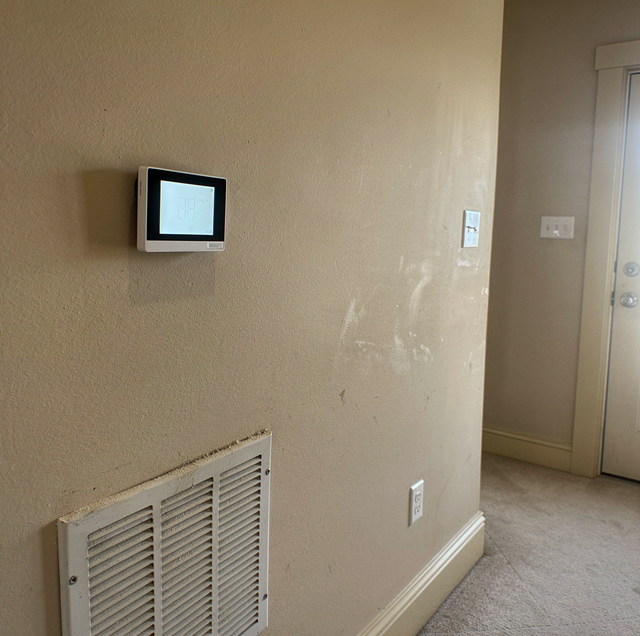 Outdoor AC condenser unit running in side yard
