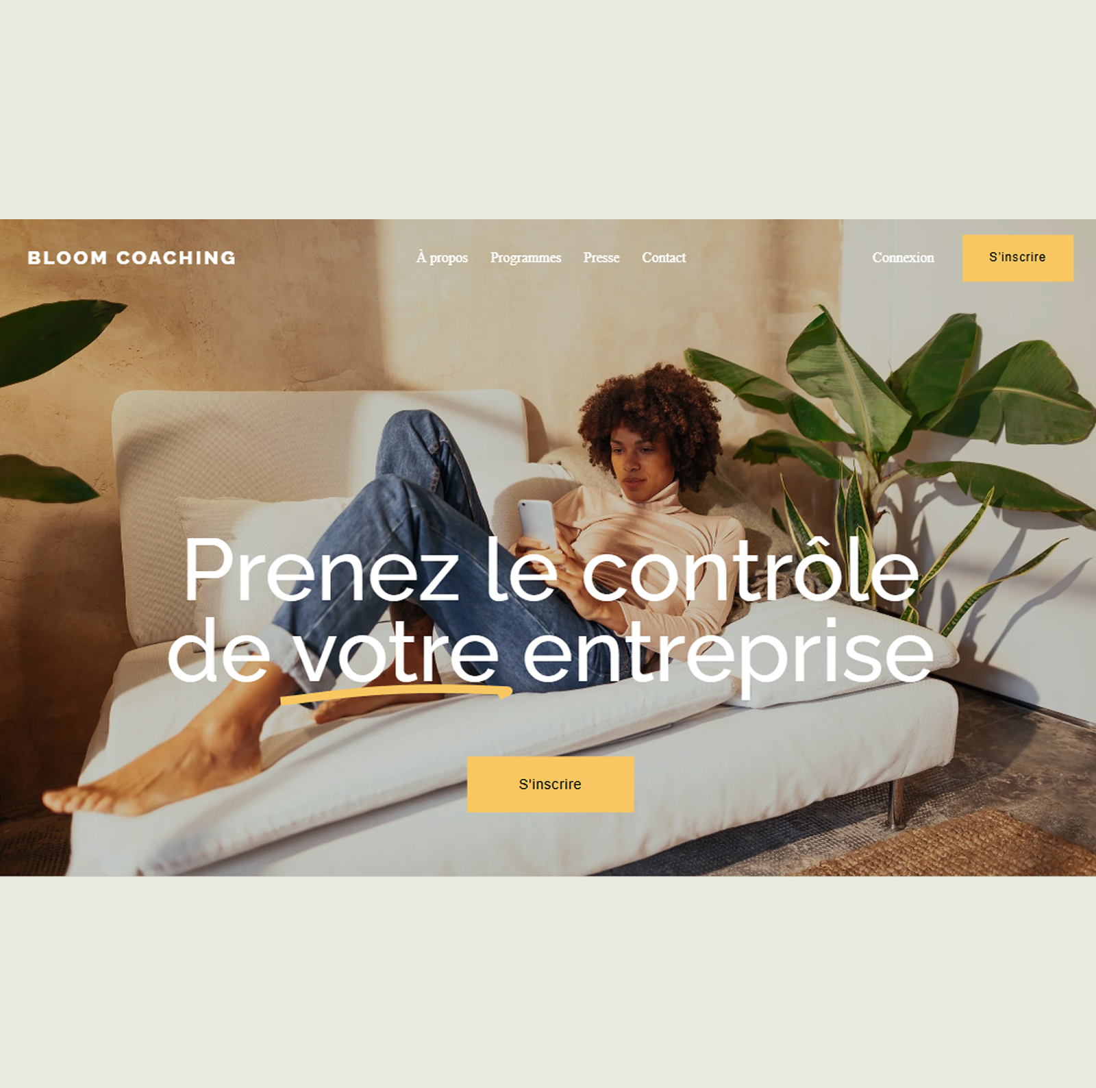 Template de site web : Une femme assise sur un canapé, utilisant son téléphone portable, à côté de deux plantes vertes, dans une pièce au mur beige.