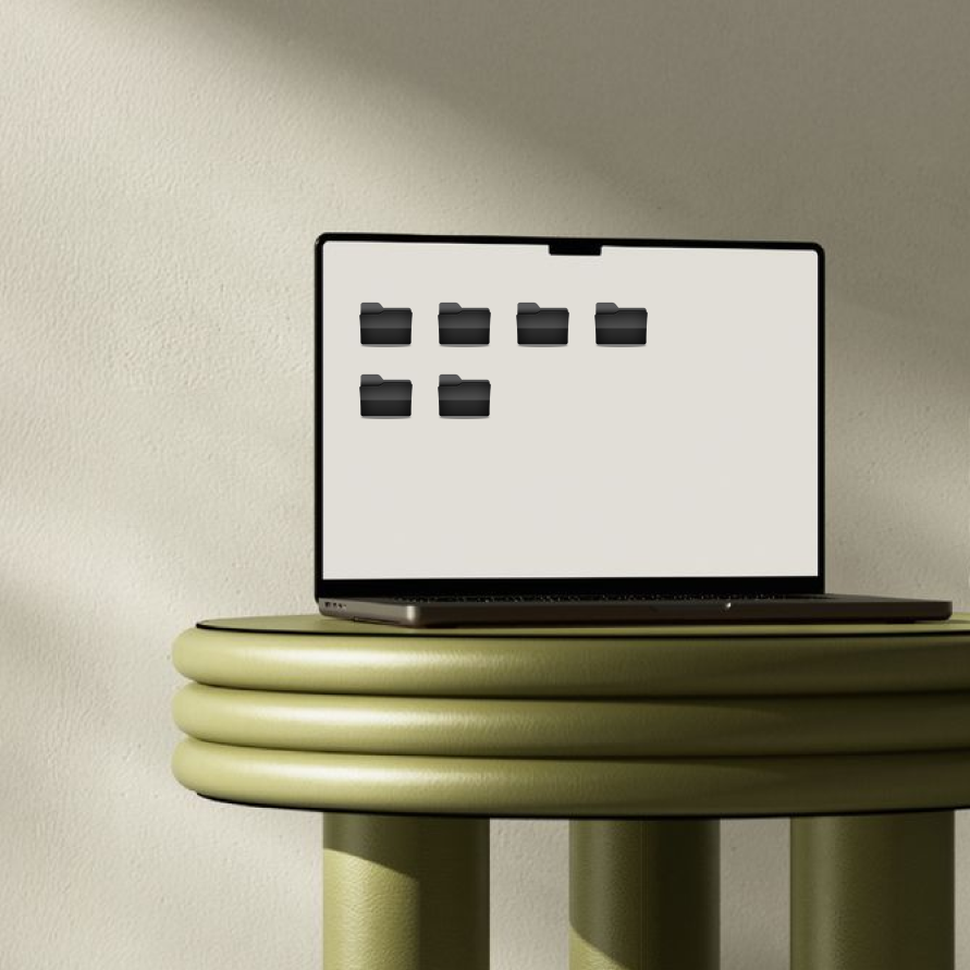 Un ordinateur portable posé sur une table verte, avec des icônes de dossiers sur l'écran.