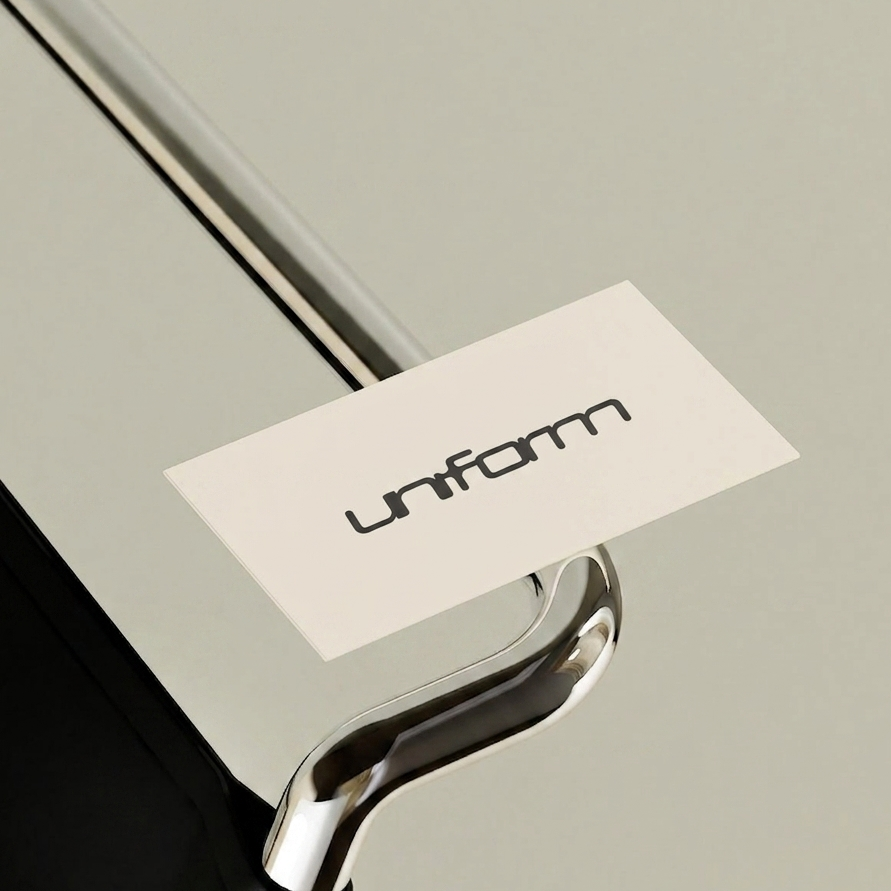 Une table en métal avec une étiquette blanc portant le mot 'Uniform' et une poignée en chrome.