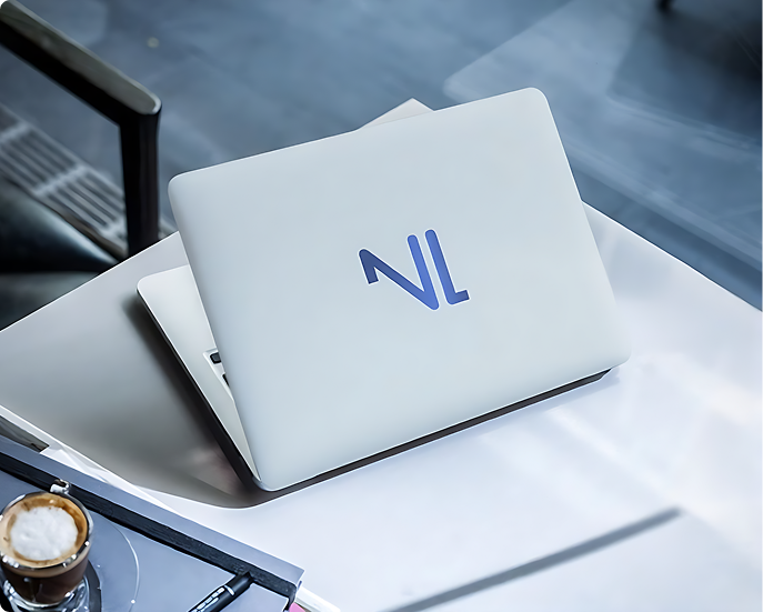 Deux ordinateurs portables empilés, le dessus avec un logo bleu encore visible.