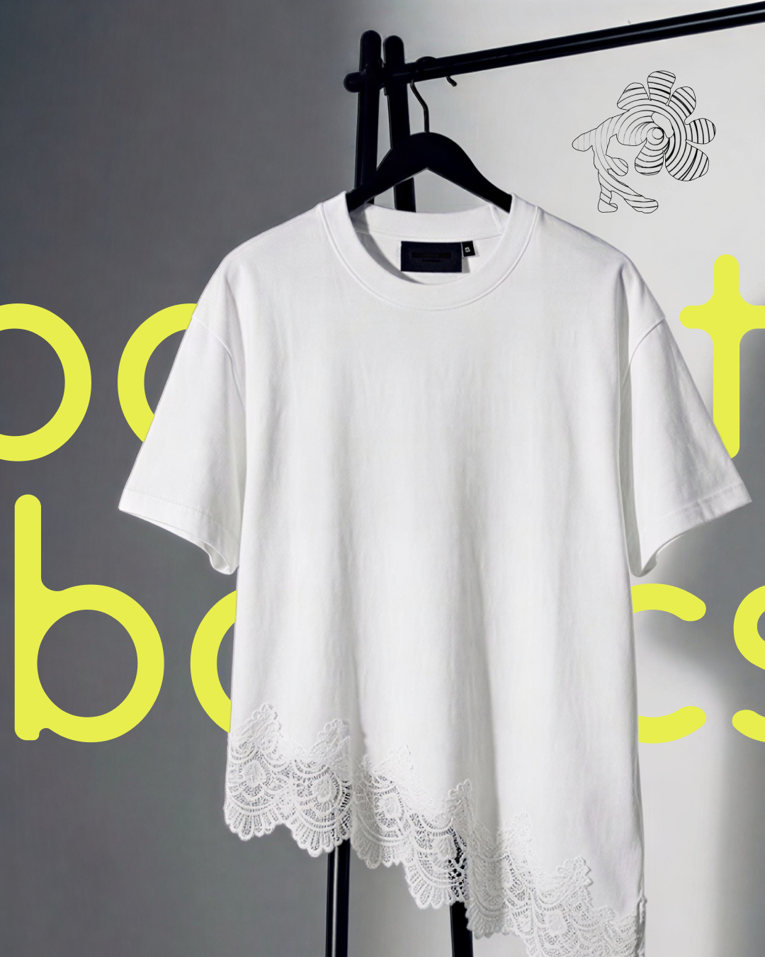 T-shirt blanc avec dentelle en bas, suspendu sur un cintre, avec un fond gris clair et un décor minimaliste.