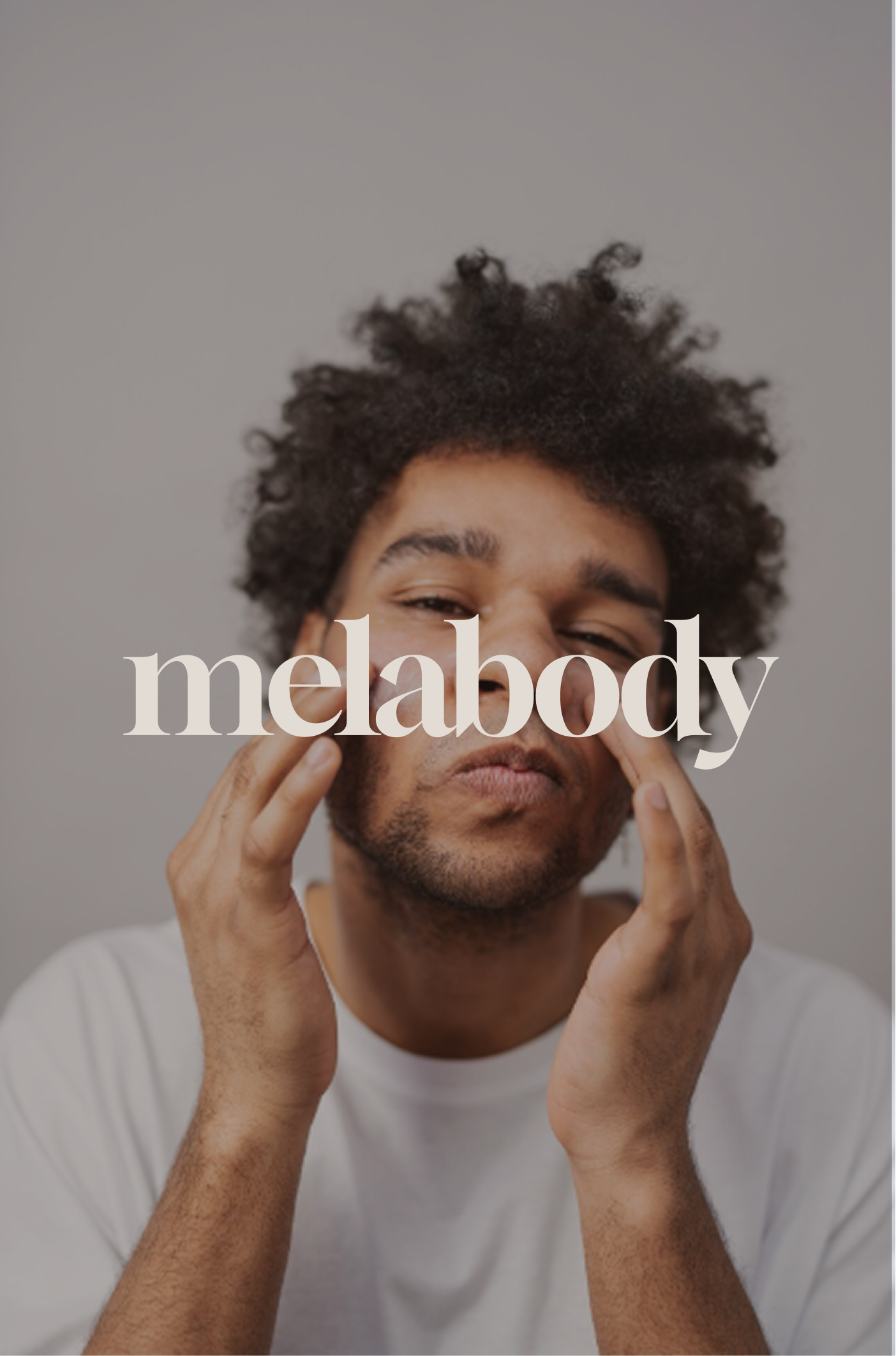 Un homme avec des cheveux bouclés, portant un t-shirt blanc, se touche le visage avec les mains. Sur l'image, le mot 'melabody' est écrit en blanc en lettres majuscules.