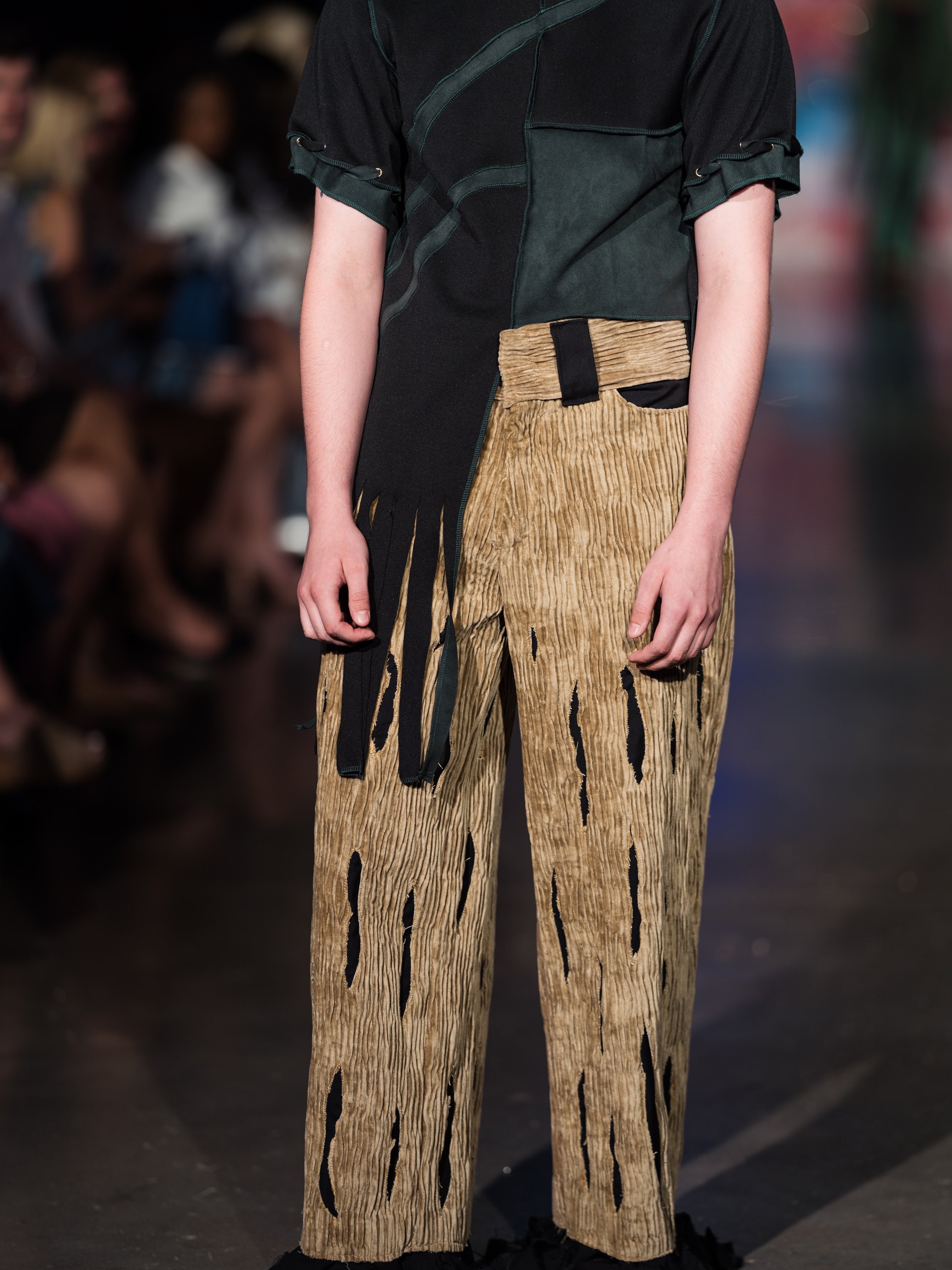 Look nine 

This look was designed to embody the image of a decaying tree. The pants represent the trunk, with peek a boo panels of black fabric emerging through the exterior to highlight the decaying touch of man kind. The exposed roots emphasize th