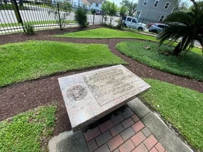 The Cradle time capsule in the garden surrounded by garden beds and a black metal fence.