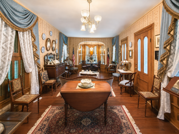The Cradle - birthplace of DRT, a Victorian-era building with a dropped desk, antique furniture, wall decor, curtains, and American flags.
