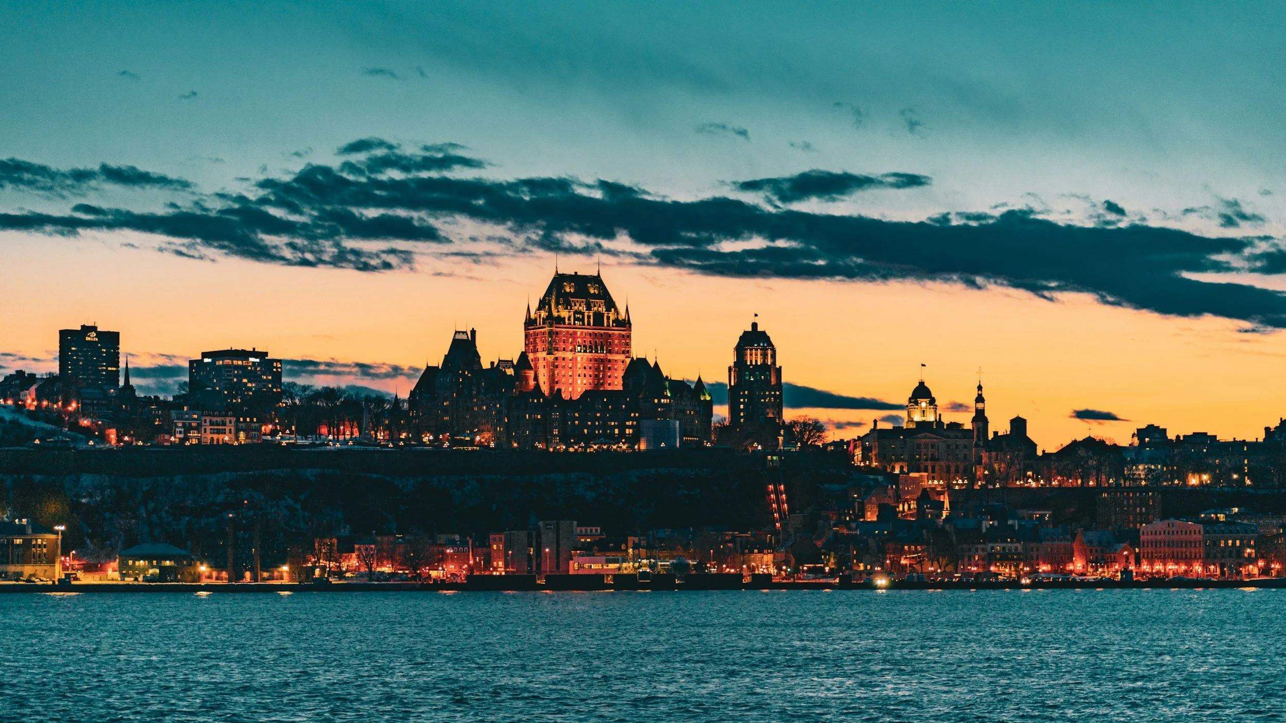 Québec City skyline glowing at sunset along the St. Lawrence River