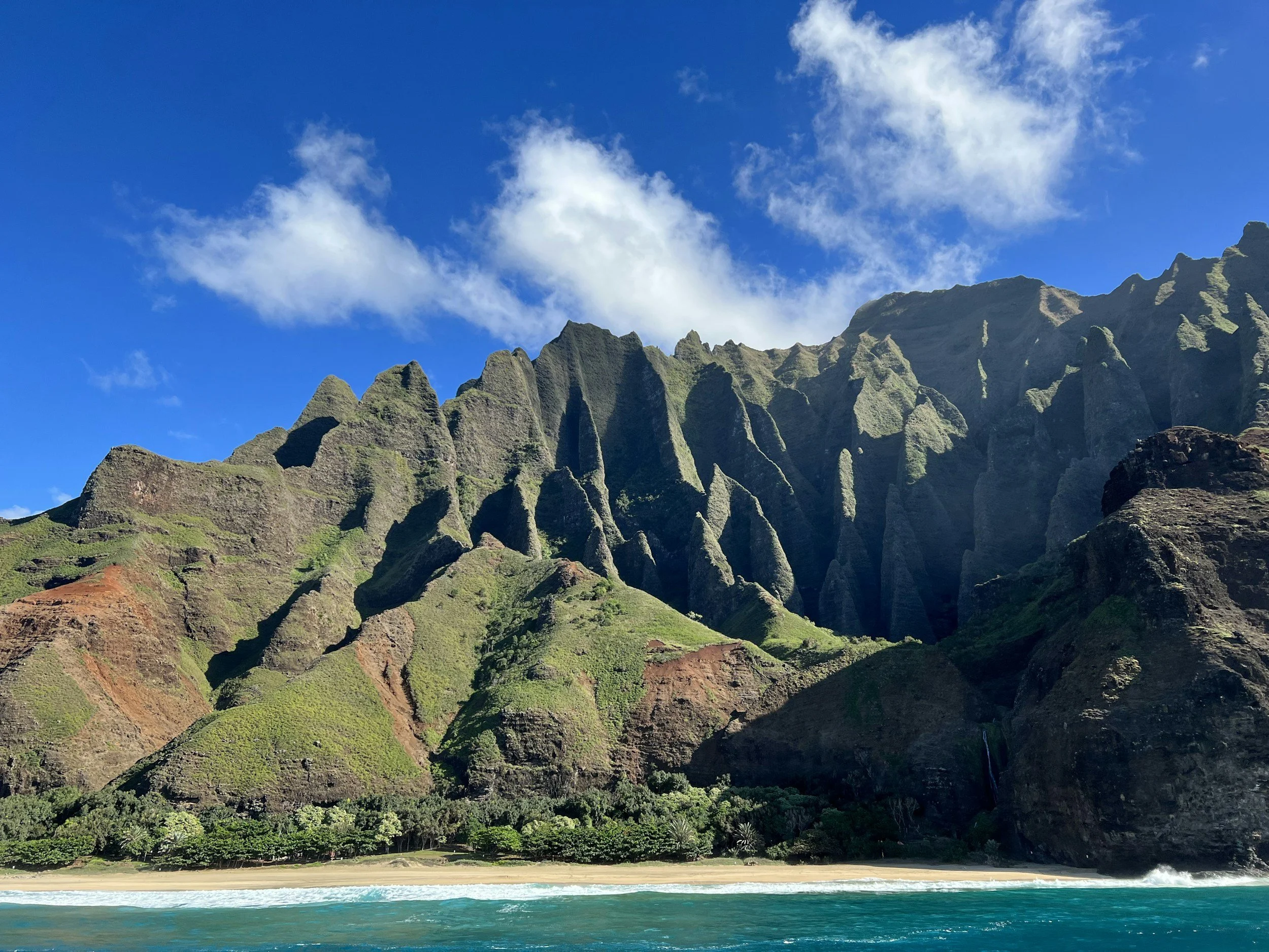 Green fluted cliffs of the Nāpali Coast rising above the sea on Kaua'i,