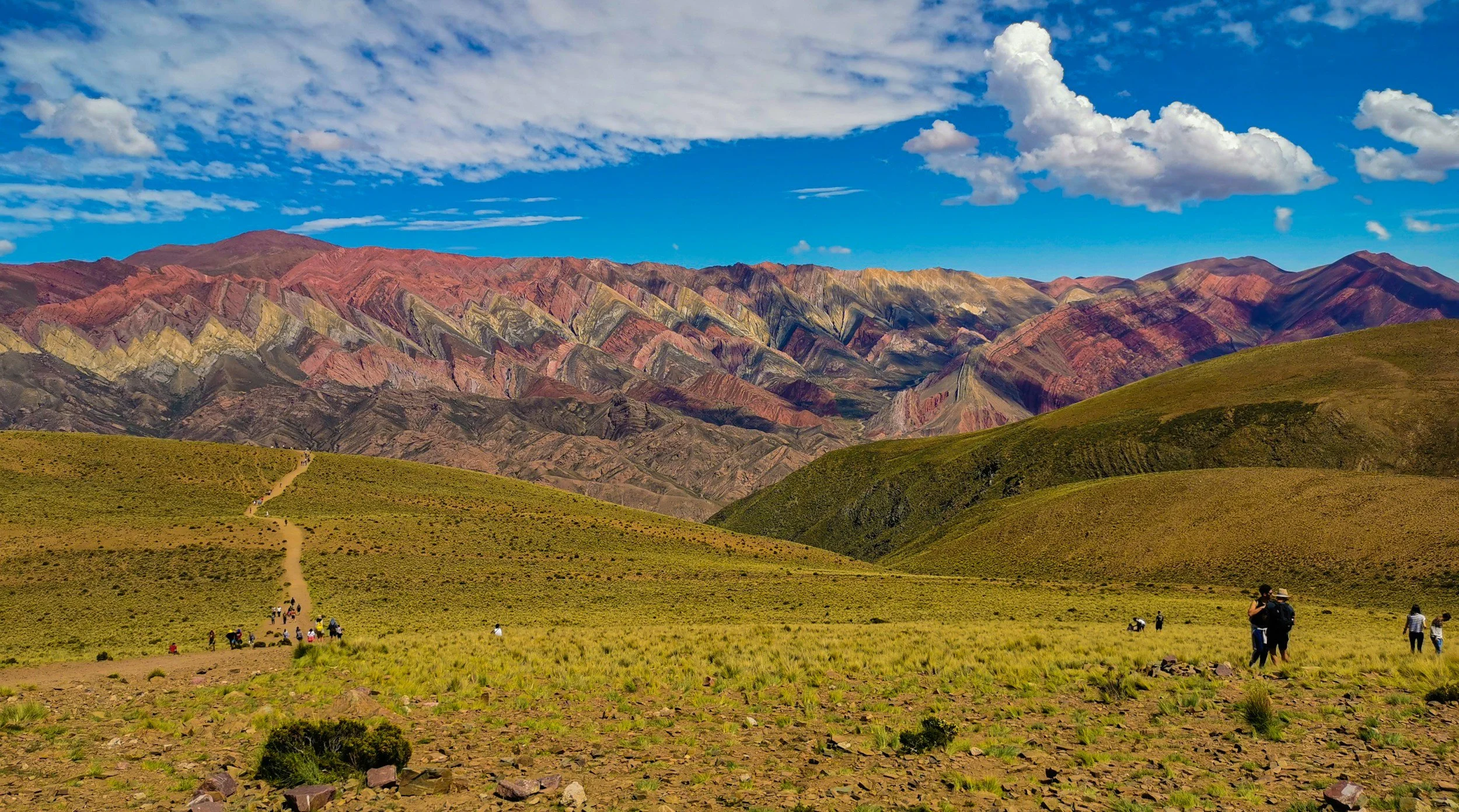 Mountains striped in red, gold, and green at Serranía de Hornocal under a bright blue sky in Jujuy.