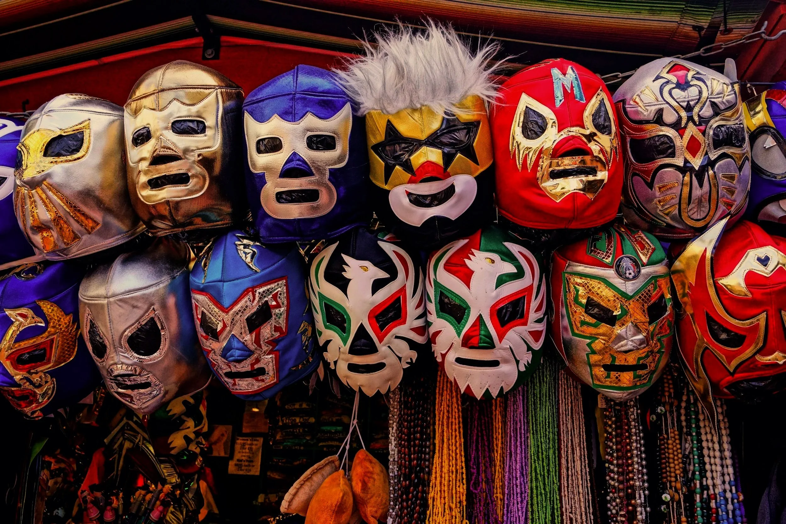 Colorful muchador masks hanging on a wall at Arena México