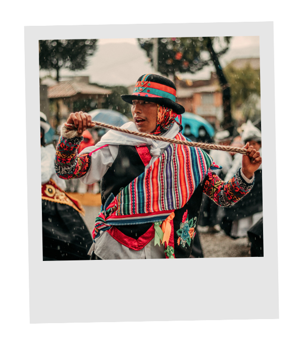 A Peruvian man in a vibrant woven poncho and embroidered hat, dancing with a rope at a traditional Andean festival.