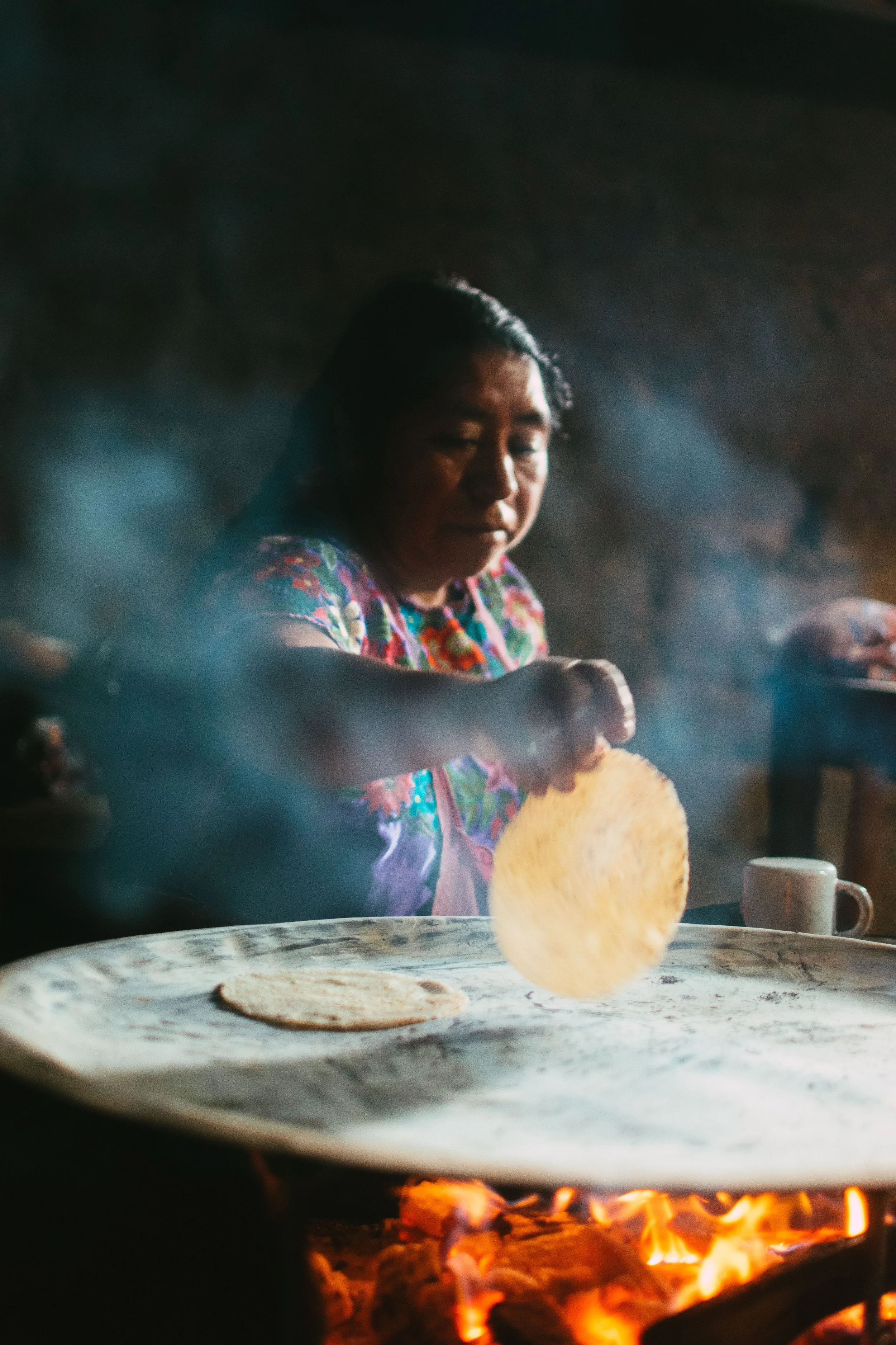 A woman cooking homemade tortillas