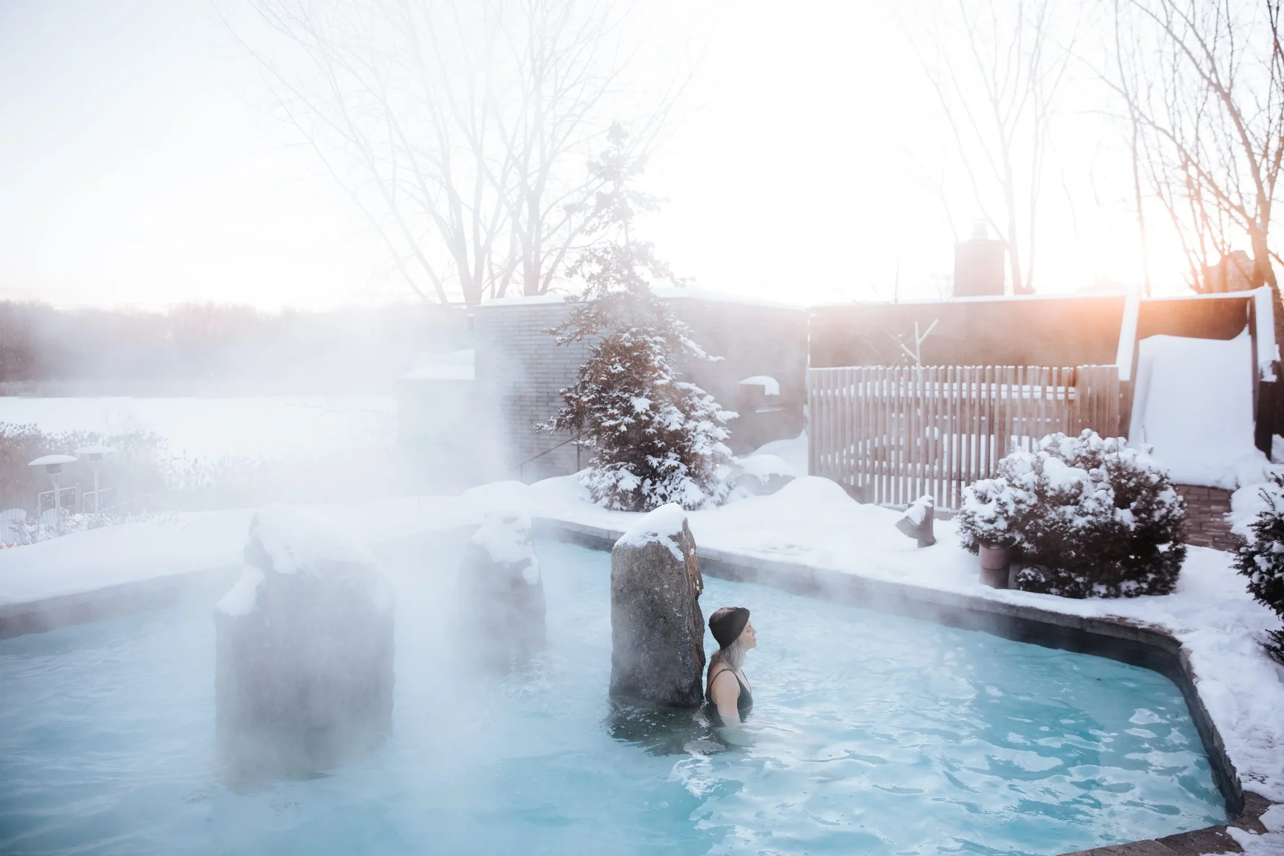 Steam rising from the outdoor thermal pools at Strøm Nordic Spa in winter near Montréal, Québec.