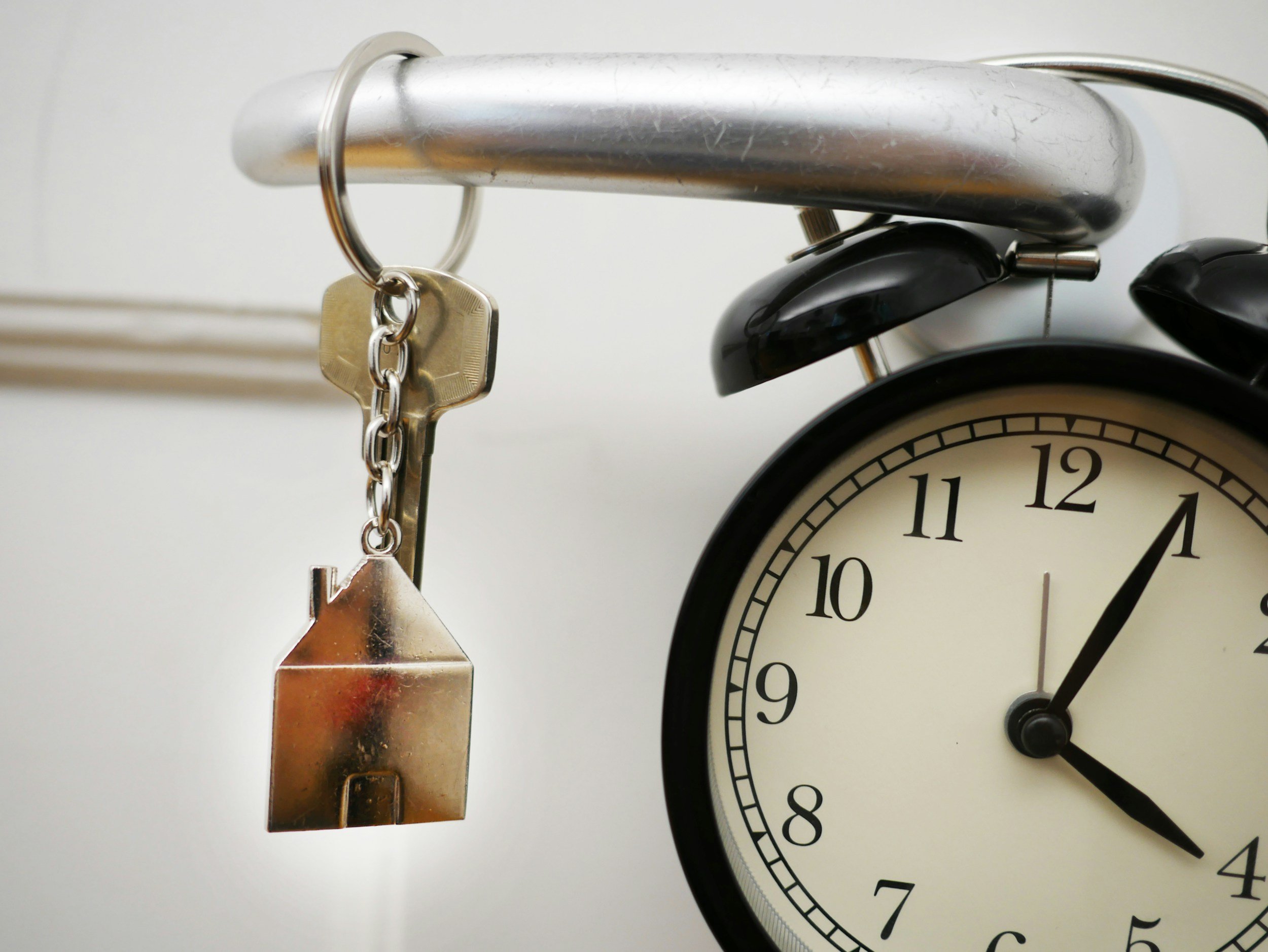 Close-up of a vintage clock with a metal ring and lock attached to its top.
