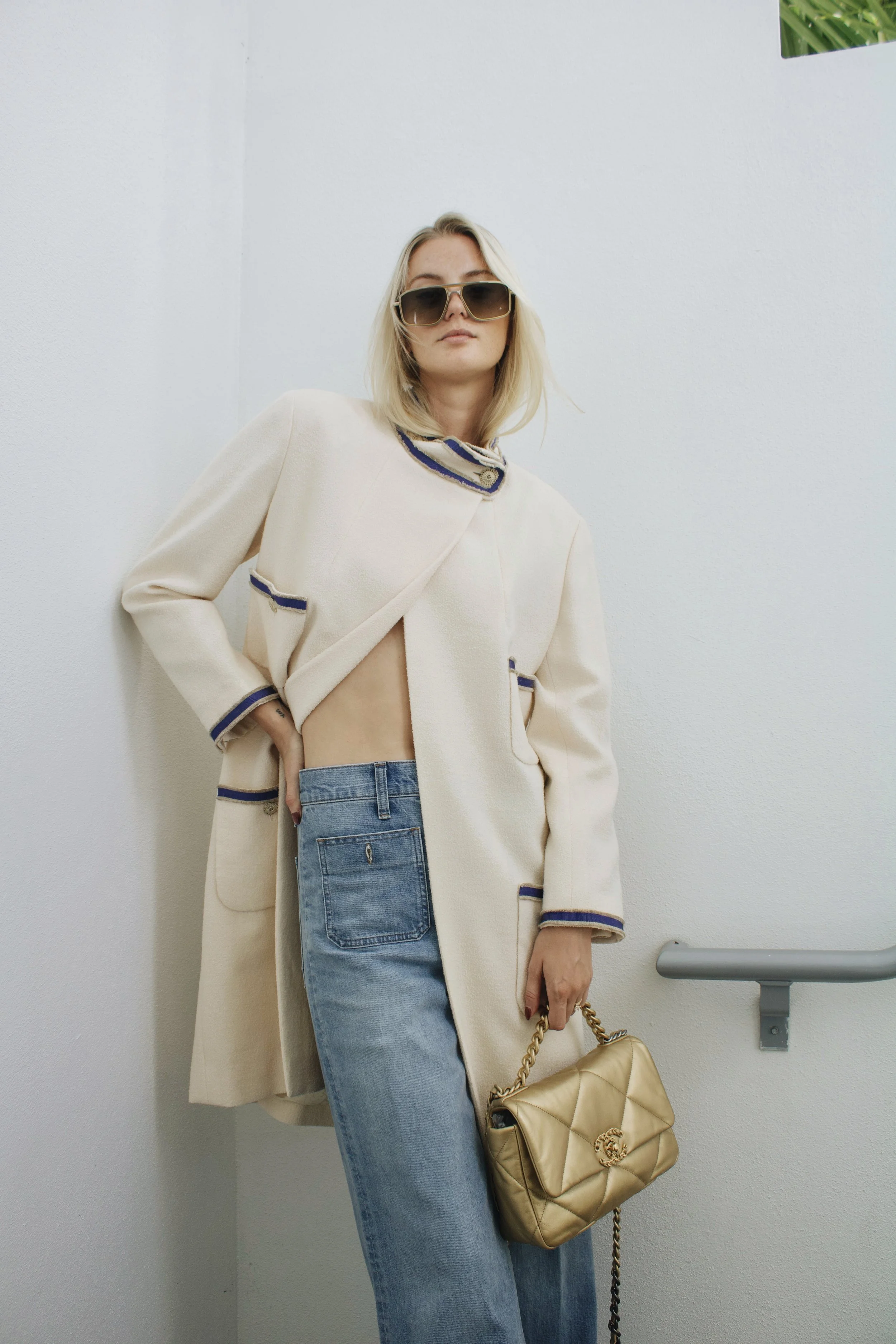 editorial fashion photoshoot of a model wearing a chanel coat and holding a gold chanel 19 bag