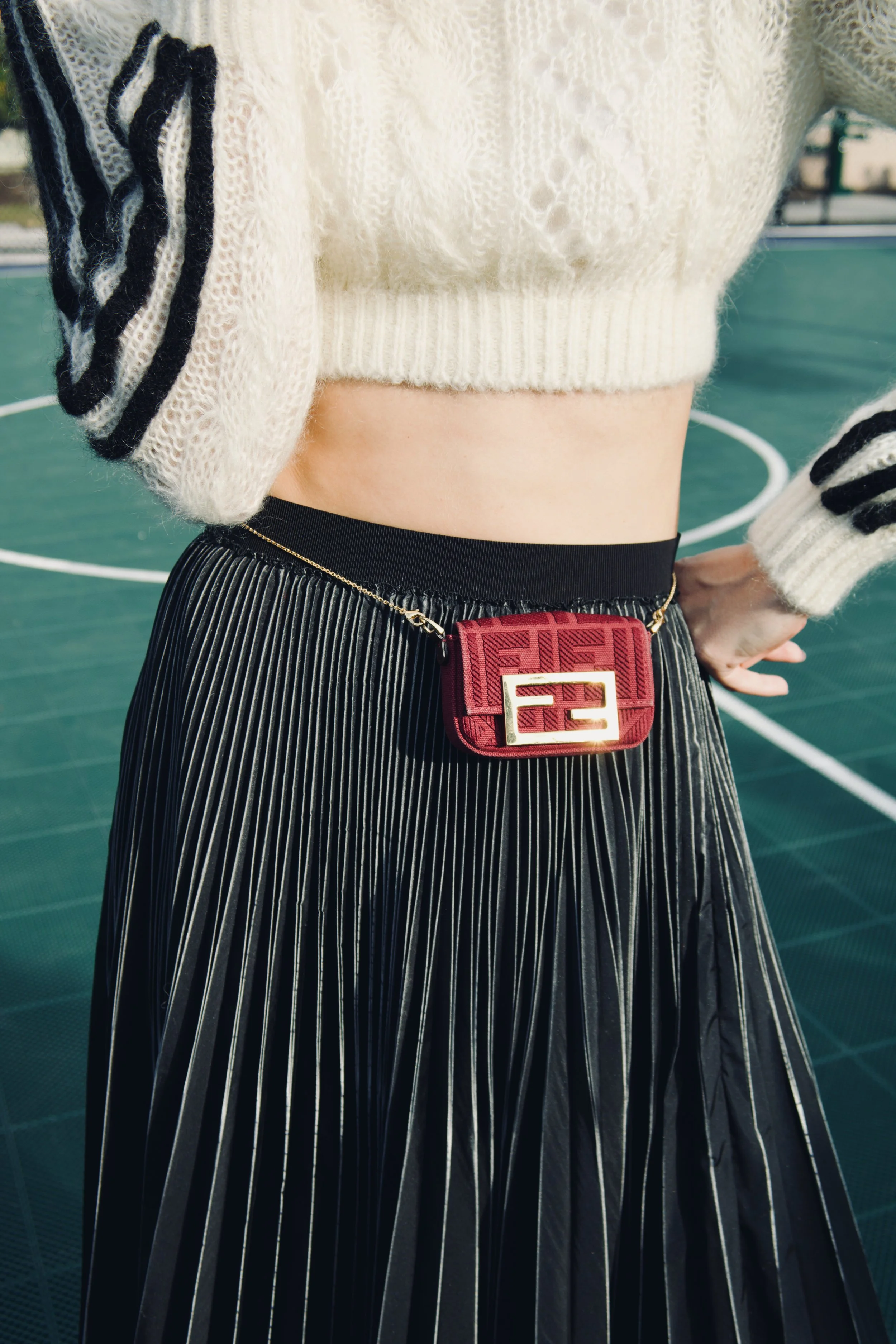fendi burgundy mini bag worn around a model's waist