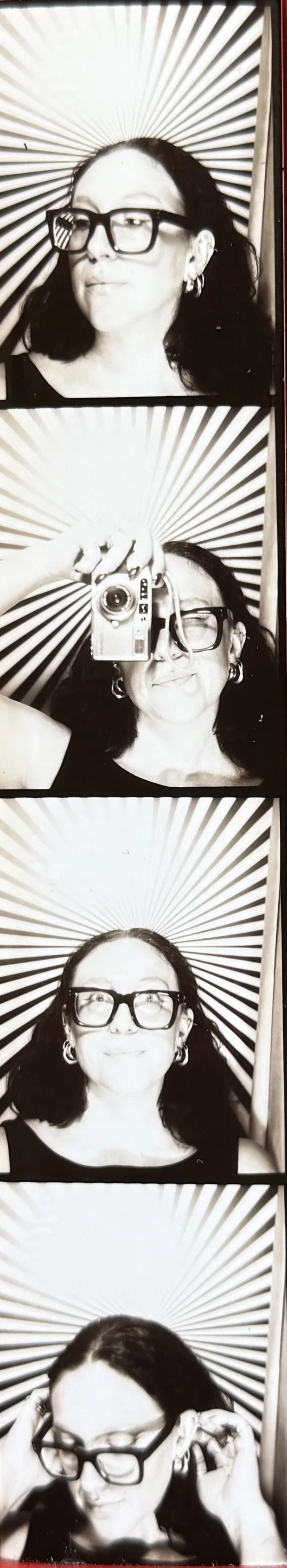 Black and white photo strip with four images of a woman with dark hair and glasses, lying against a starburst patterned background. She is posing playfully in each picture.
