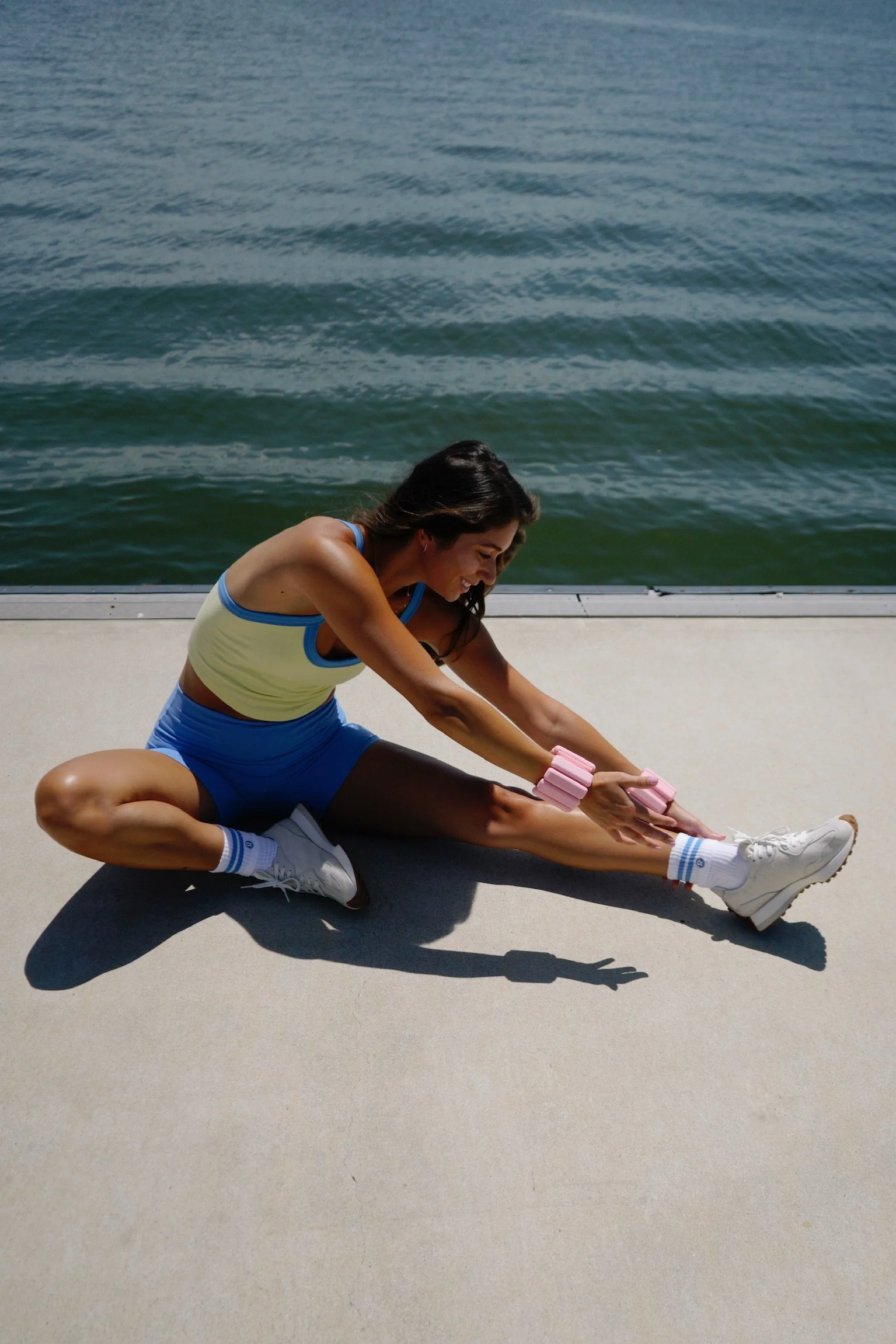 pilates teacher demonstrating movement while outside next to the ocean