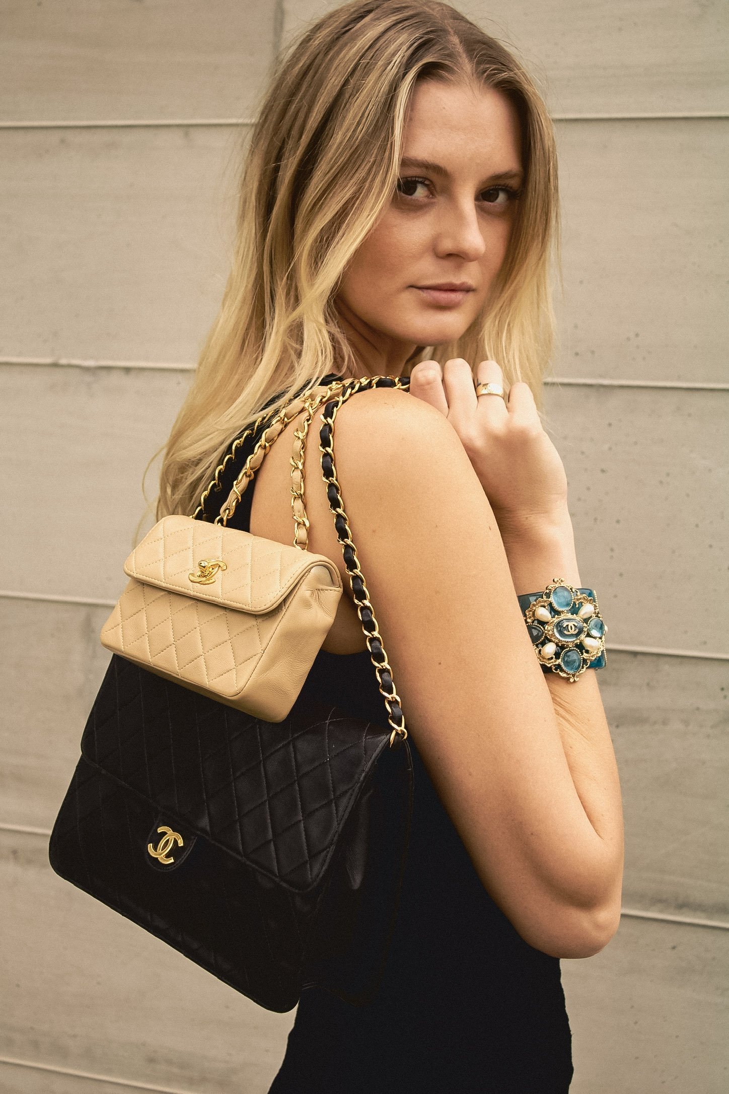 editorial shoot with model holding multiple chanel bags and wearing chanel jewelry
