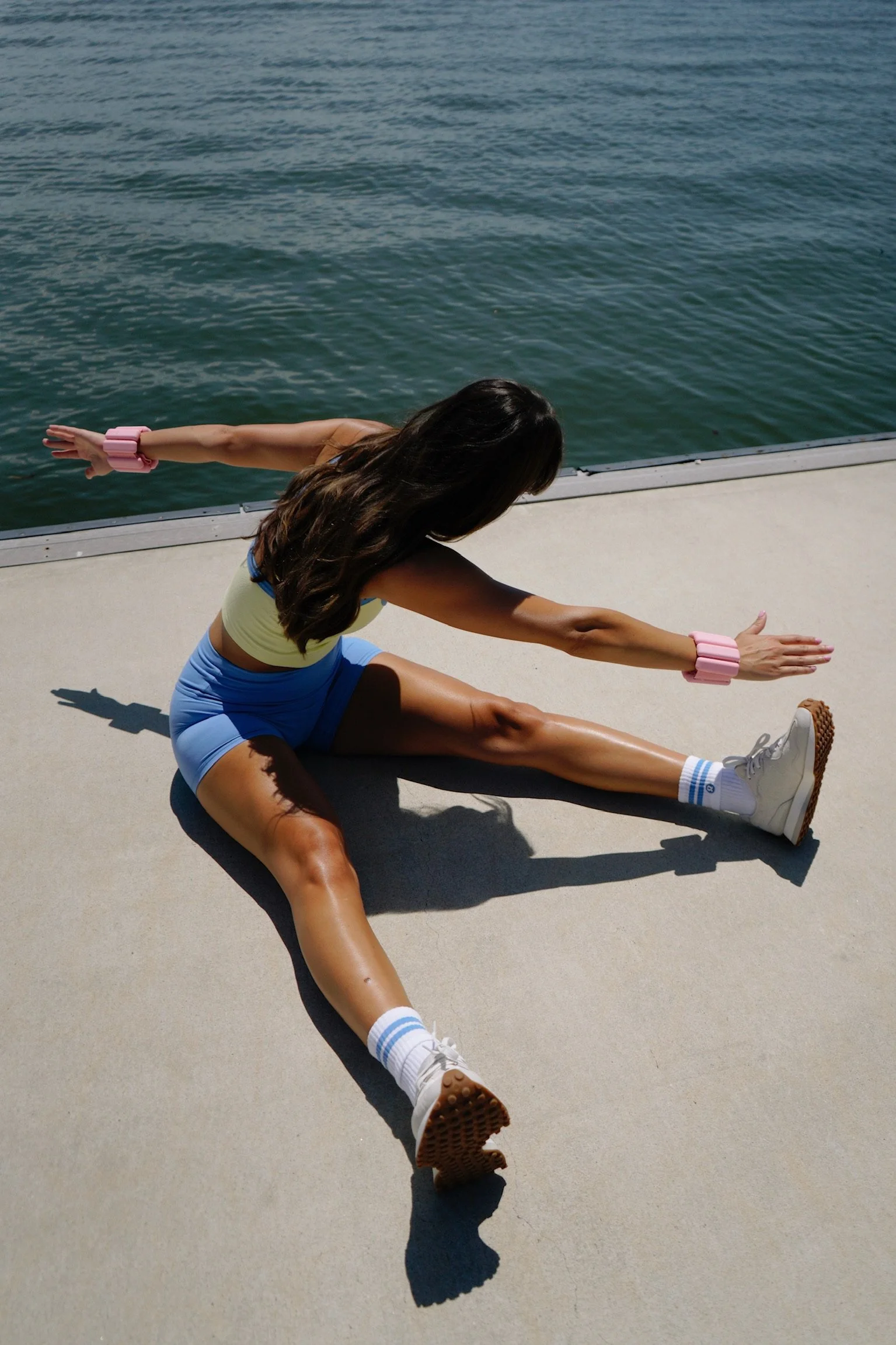 pilates teacher demonstrating movement while outside next to the ocean