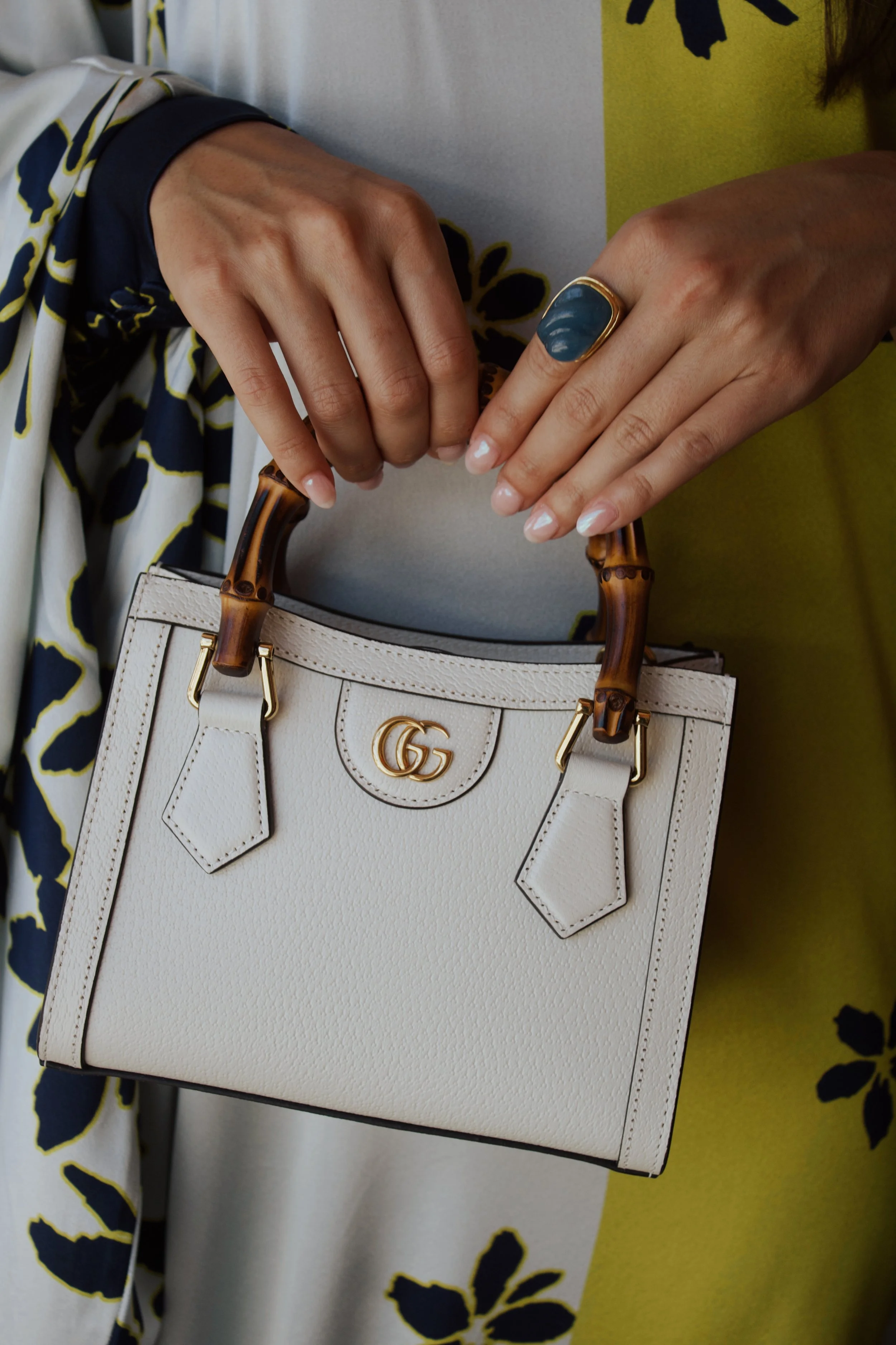 a close up photo of a model holding a gucci ivory diana bag with a bamboo handle