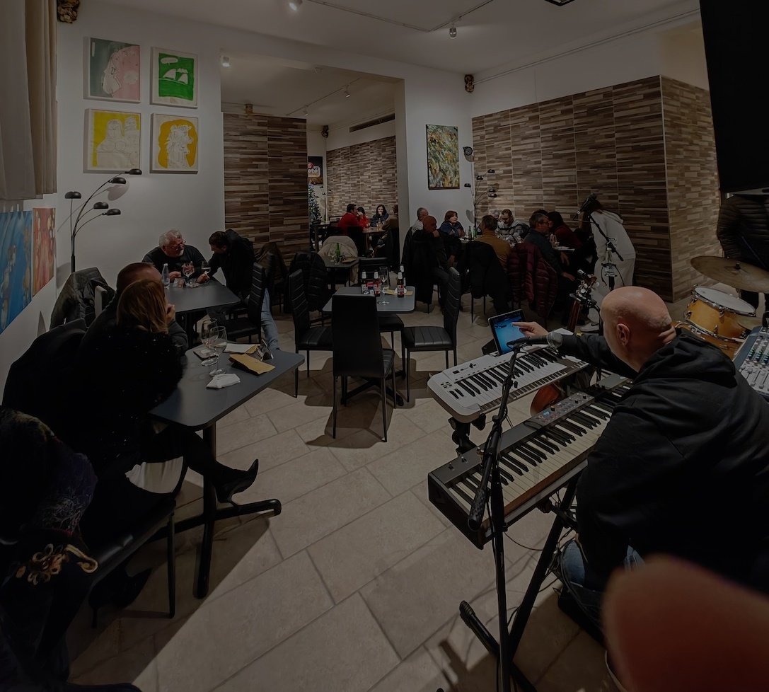 areté Food & Sound con musica dal vivo e persone sono sedute ai tavoli che ascoltano.