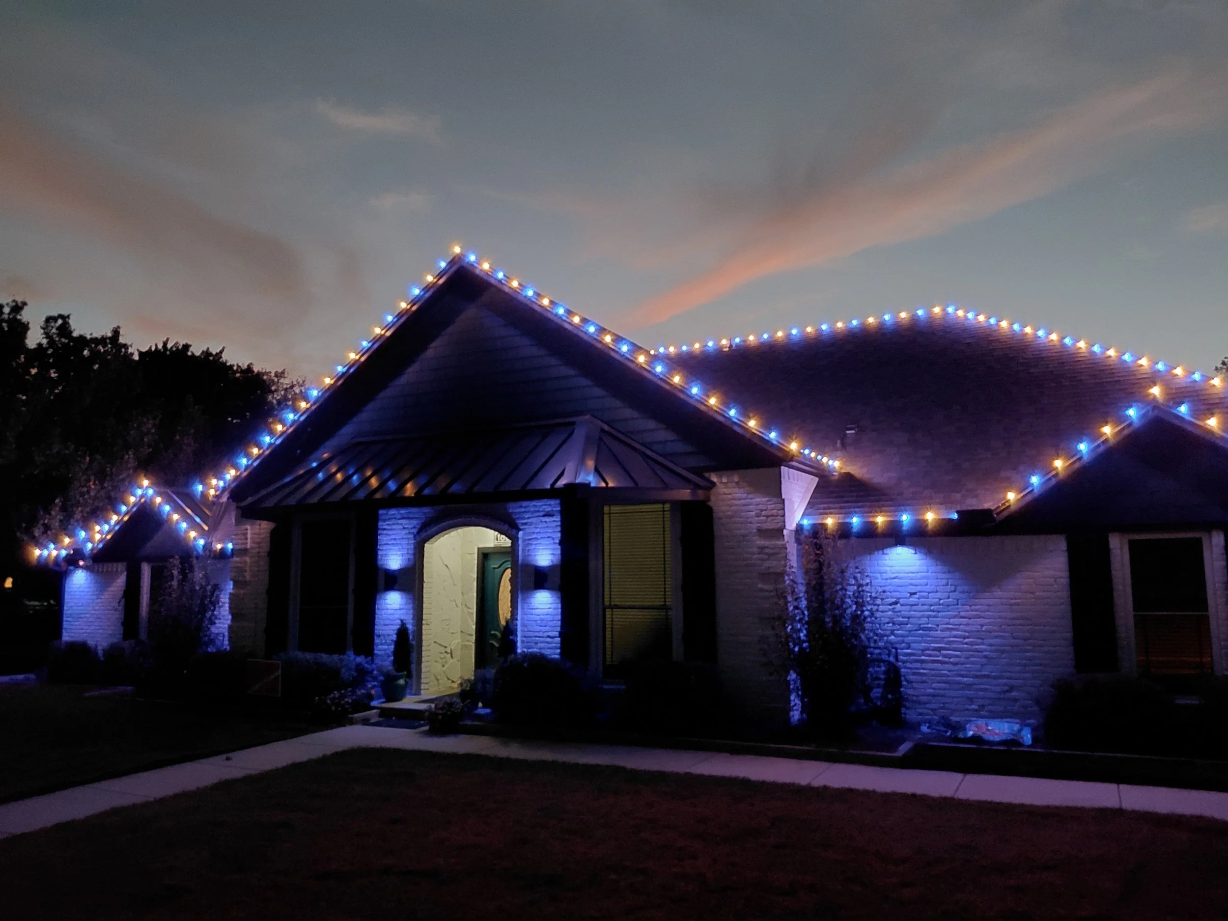 Christmas and holiday lighting installation on a home roofline with blue accent lighting, Double Oak TX