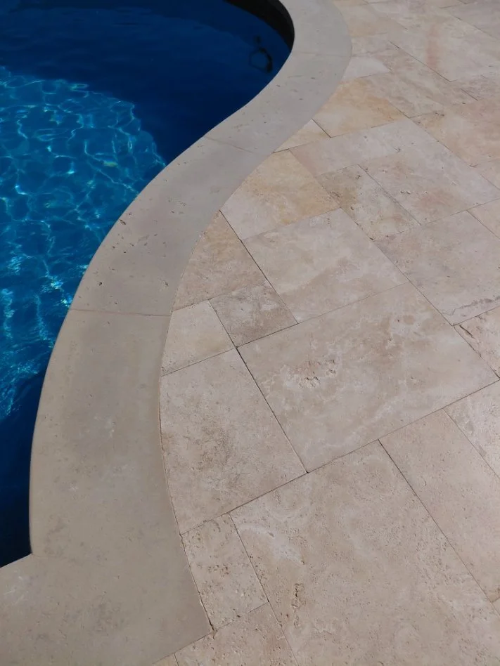 Attention to details around curved coping, with precise cuts and fitting of travertine coping