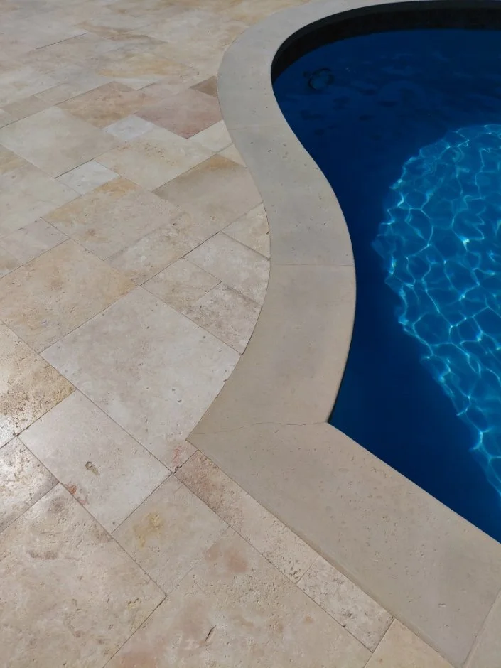 Precision fitting of travertine pool deck coping in Westlake Texas