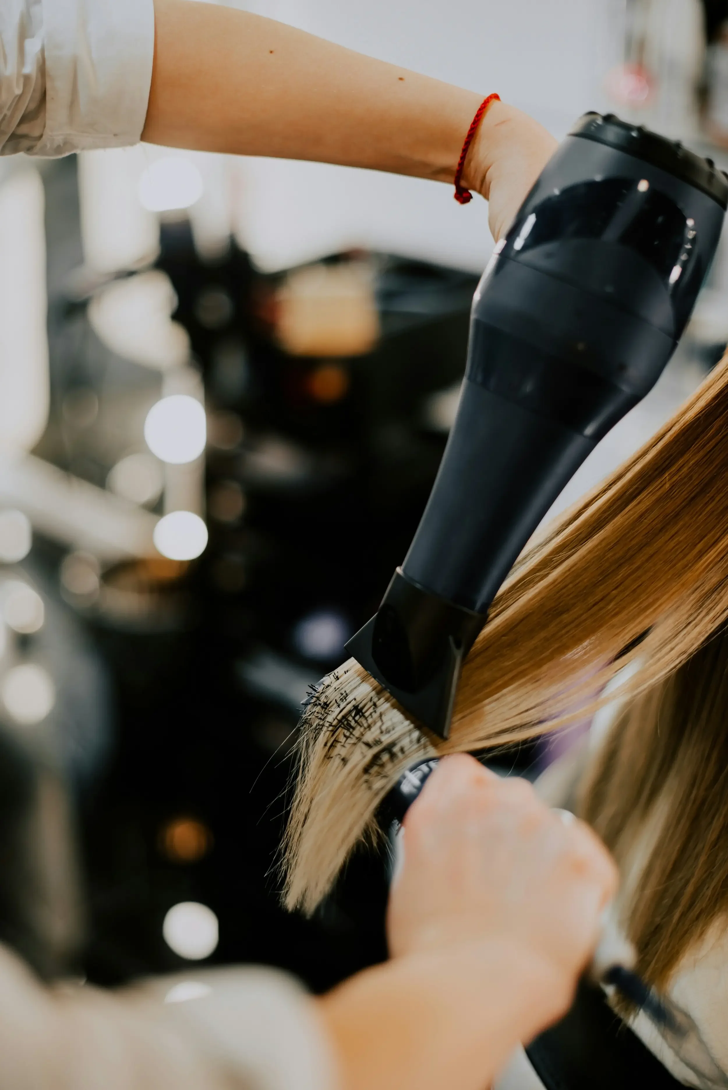 Stylist creating a smooth blowout with a round brush — special occasion and bridal styling at Itsa Salon, Puyallup WA