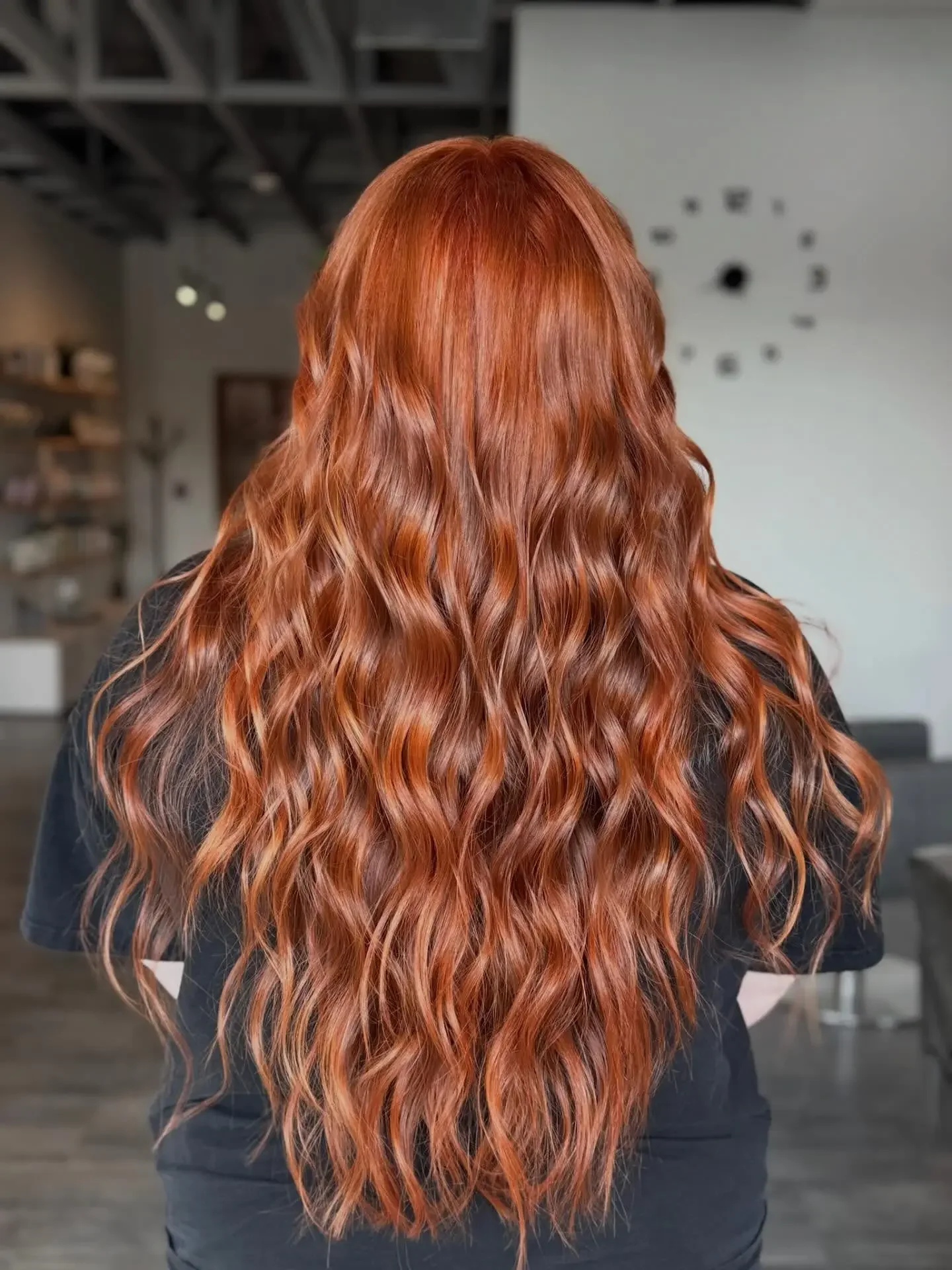 Long copper-red waves styled from the back — vivid red hair color at Itsa Salon in Puyallup, WA