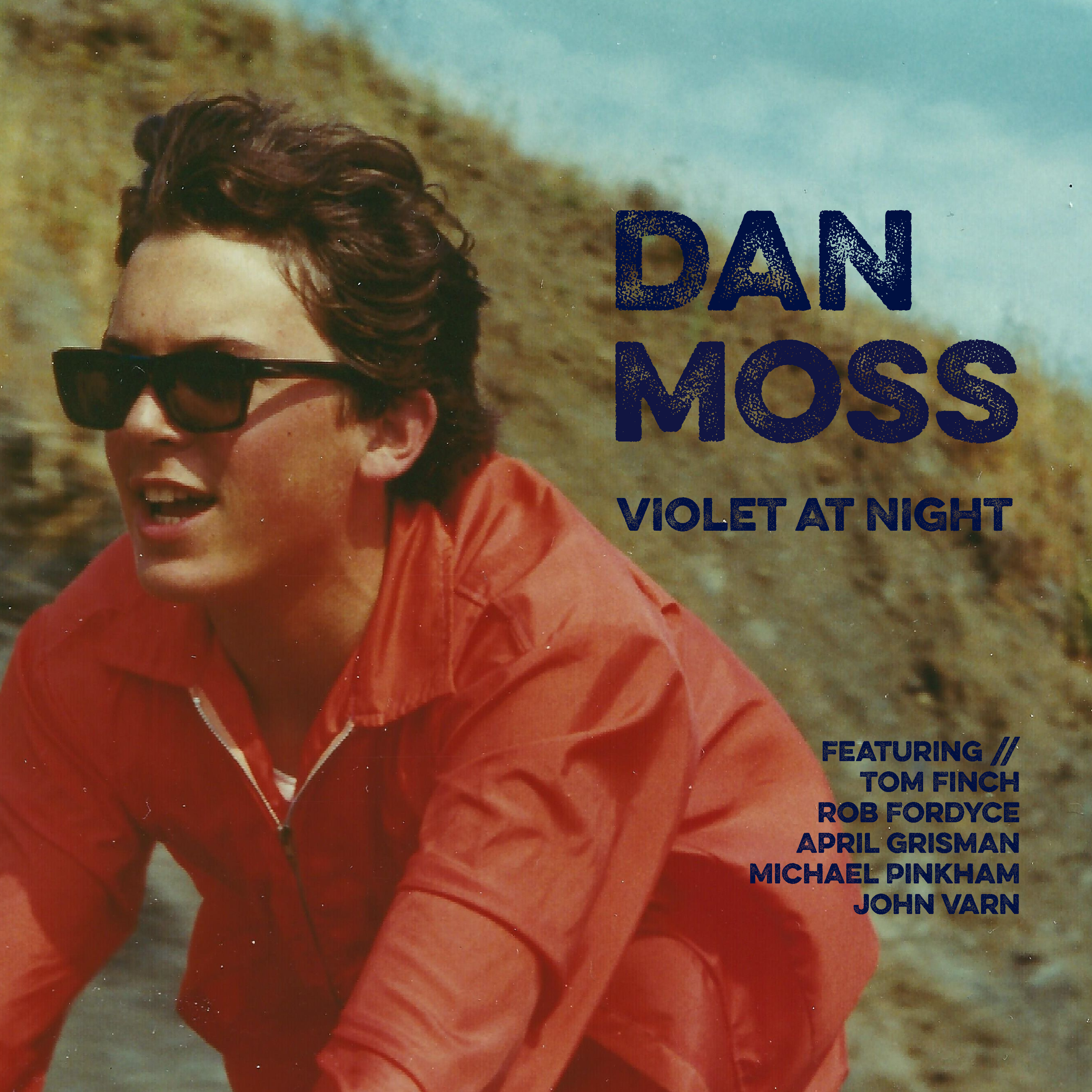 Violet at Night album cover, close-up of a person wearing dark sunglasses and a red jacket, outdoors with a rocky background.