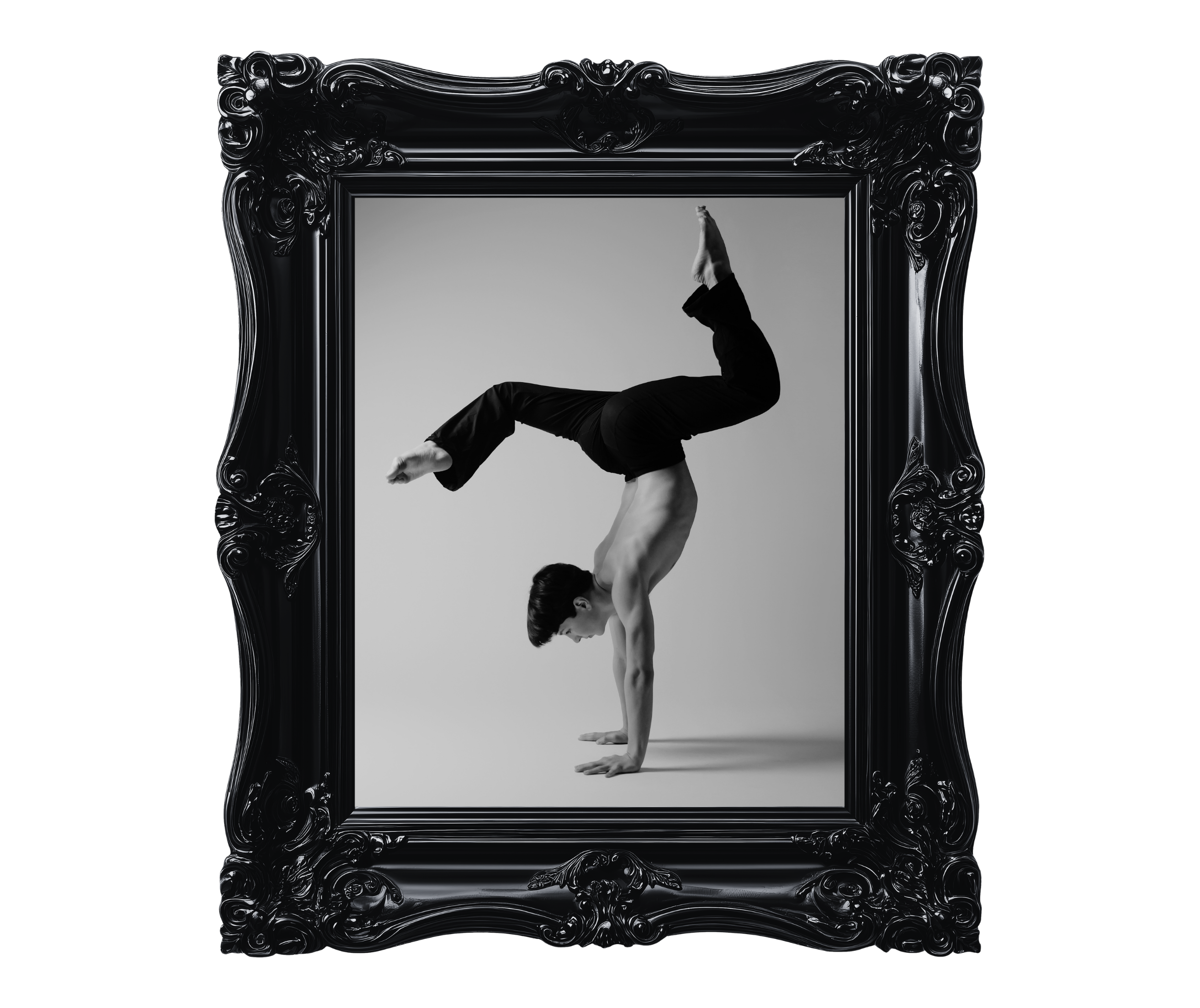 A black and white photo of a person performing a handstand inside a large ornate black picture frame. The person's legs are bent at the knees and one arm supports their body while the other arm is extended upward. The background is plain and the person is wearing dark clothing.