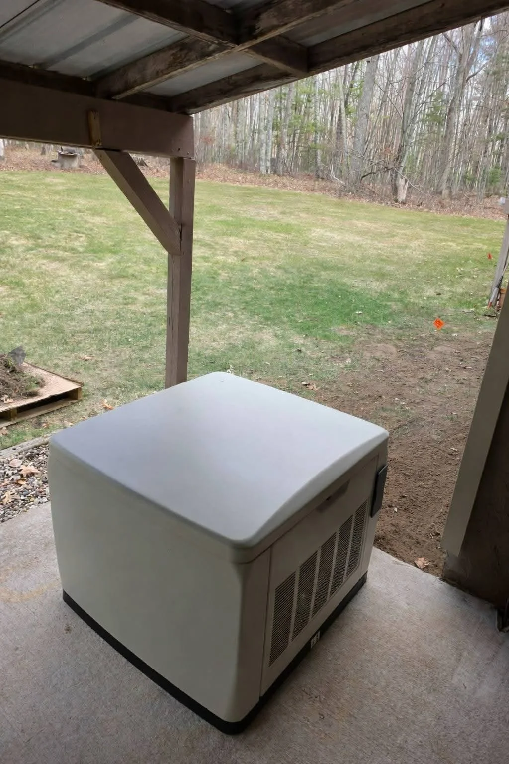 Generator covered porch — Standby home generator installed on concrete pad under covered porch by Ground & Grid Solutions