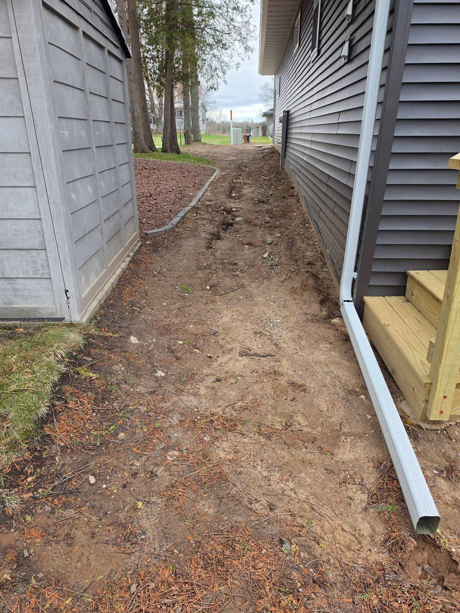 Grading — Ground clearing and grading along backyard fence line by Ground & Grid Solutions