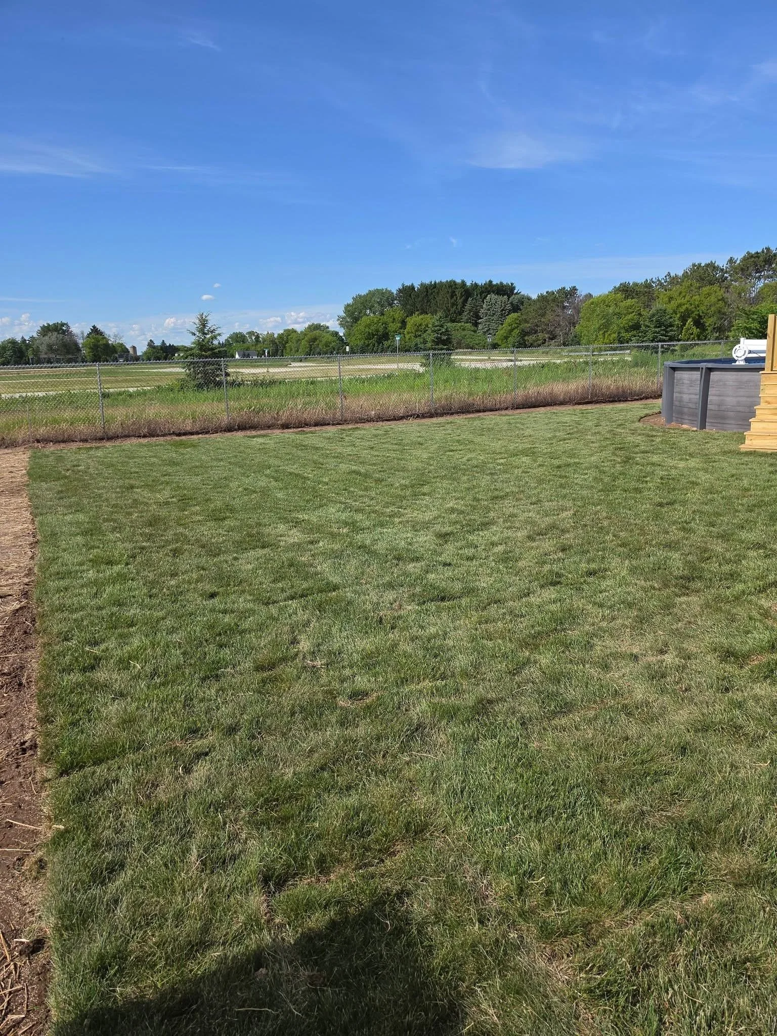 Grassy backyard — Completed lawn installation by Ground & Grid Solutions