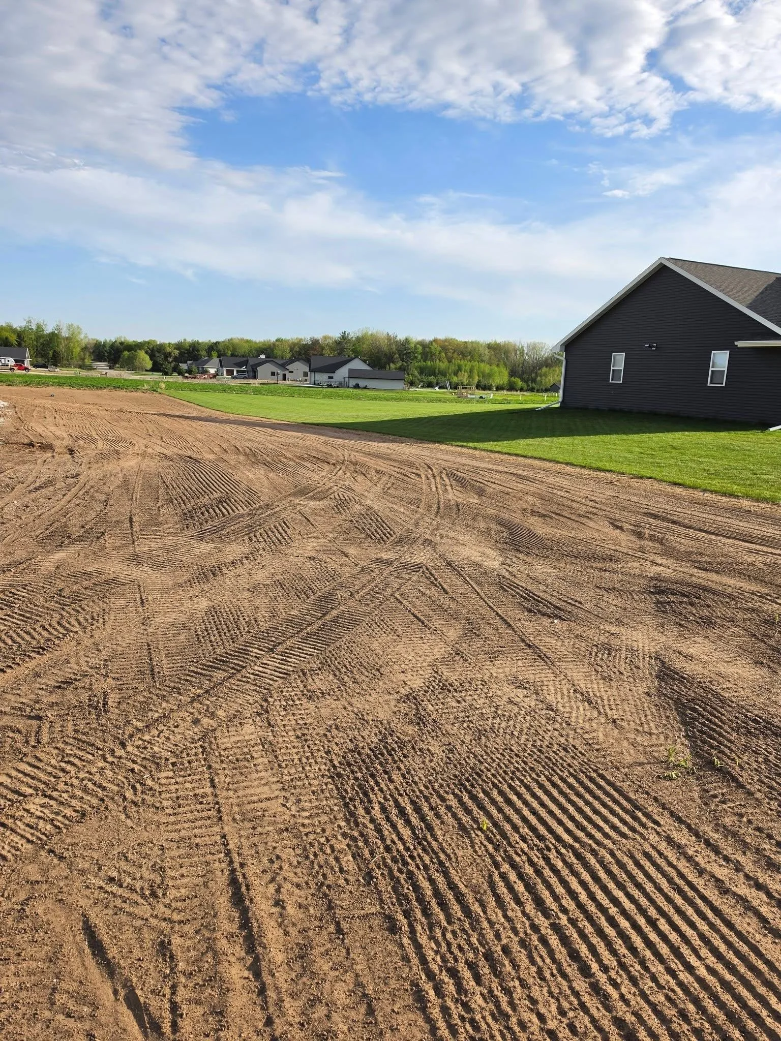 Ground grading — Large-scale finish grading with tractor showing completed ground prep by Ground & Grid Solutions