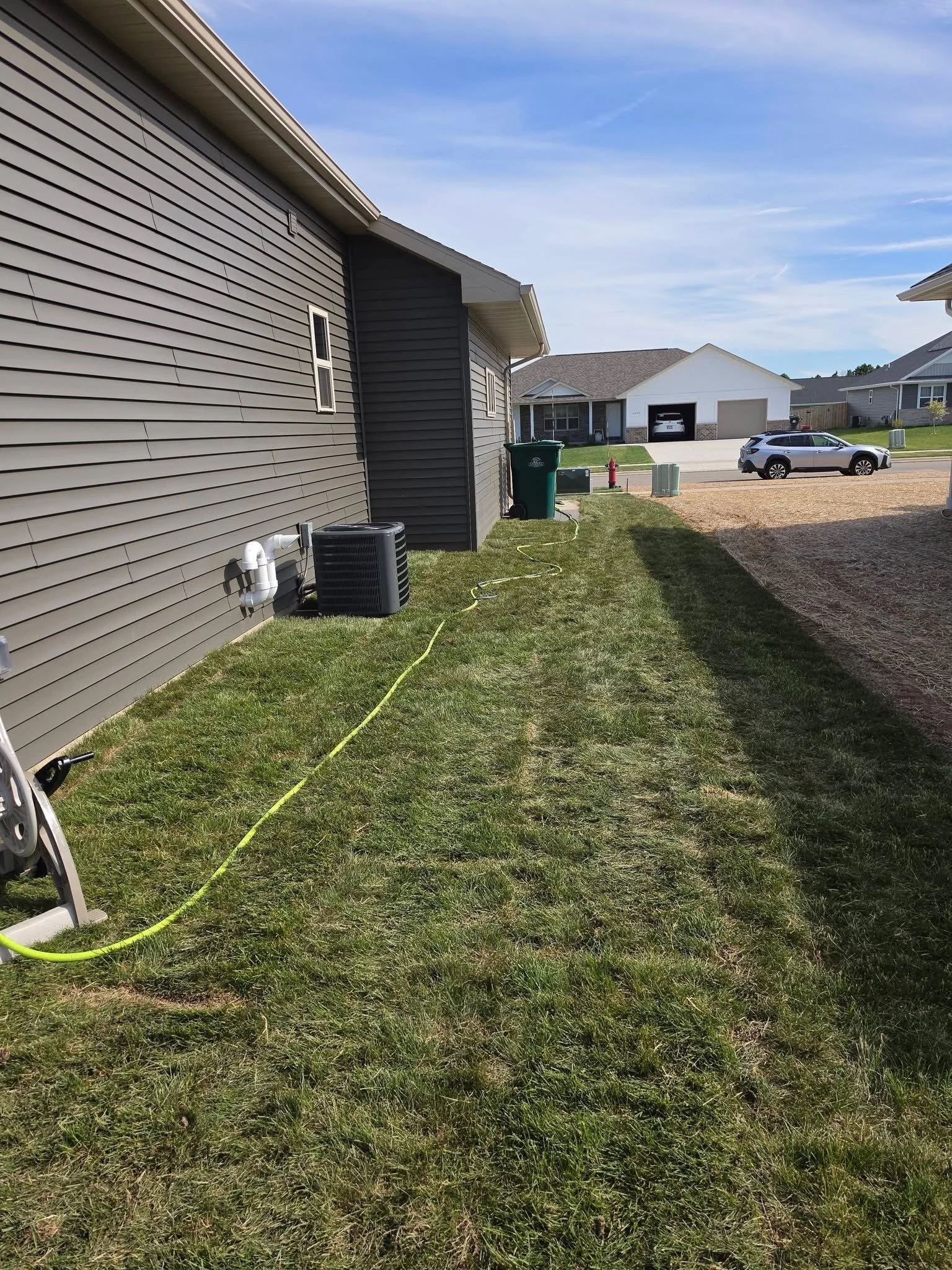 Suburban yard — Finished sod installation along house foundation by Ground & Grid Solutions