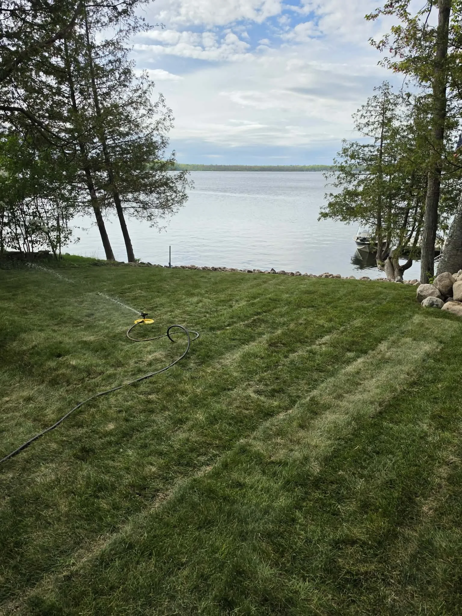 Lakefront lawn — Freshly seeded lawn leading to lakefront property, completed by Ground & Grid Solutions