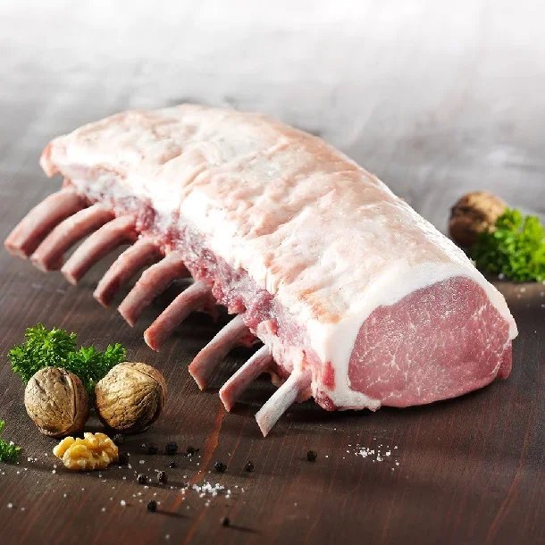 Cesar Nieto Iberico Pork French Rack 5 Ribs , fresh parsley, walnuts, garlic, and black pepper on a dark wooden surface
