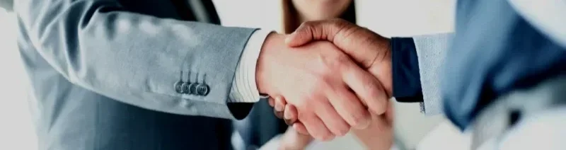 Close-up of two people shaking hands in a professional setting.
