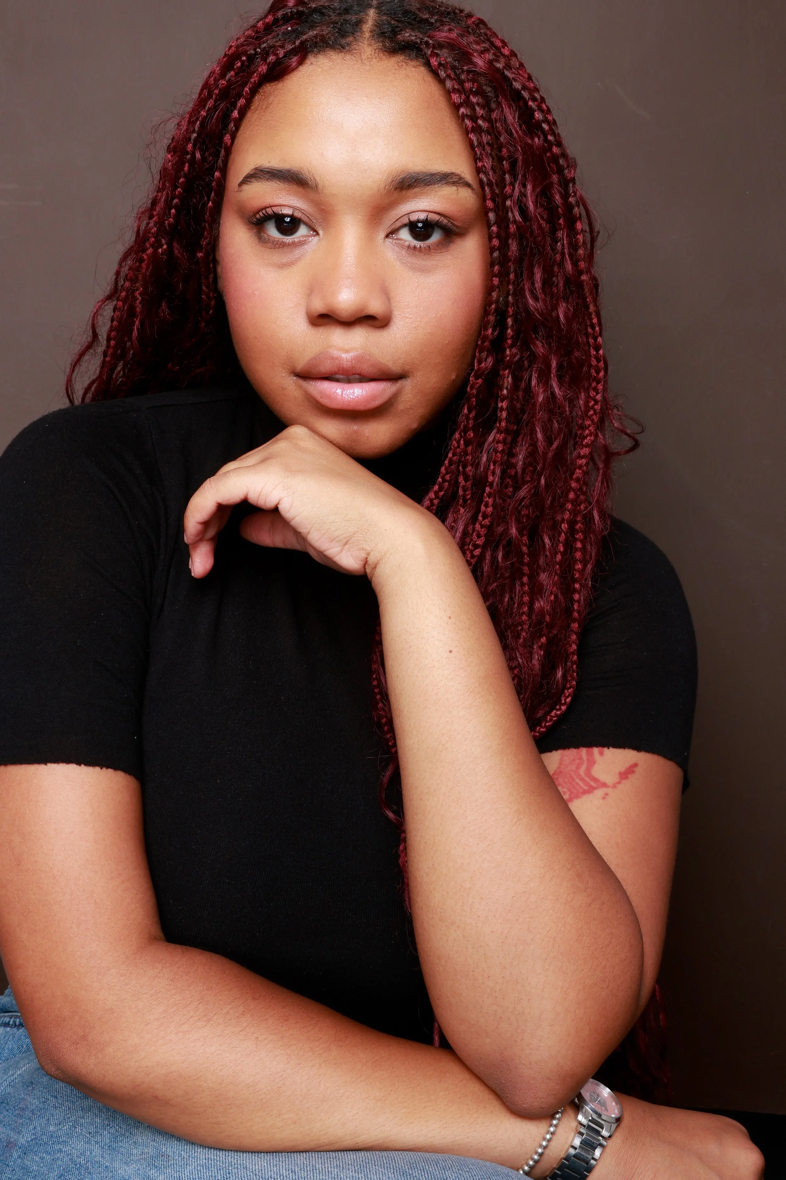 Jalexis James sitting in front of brown background