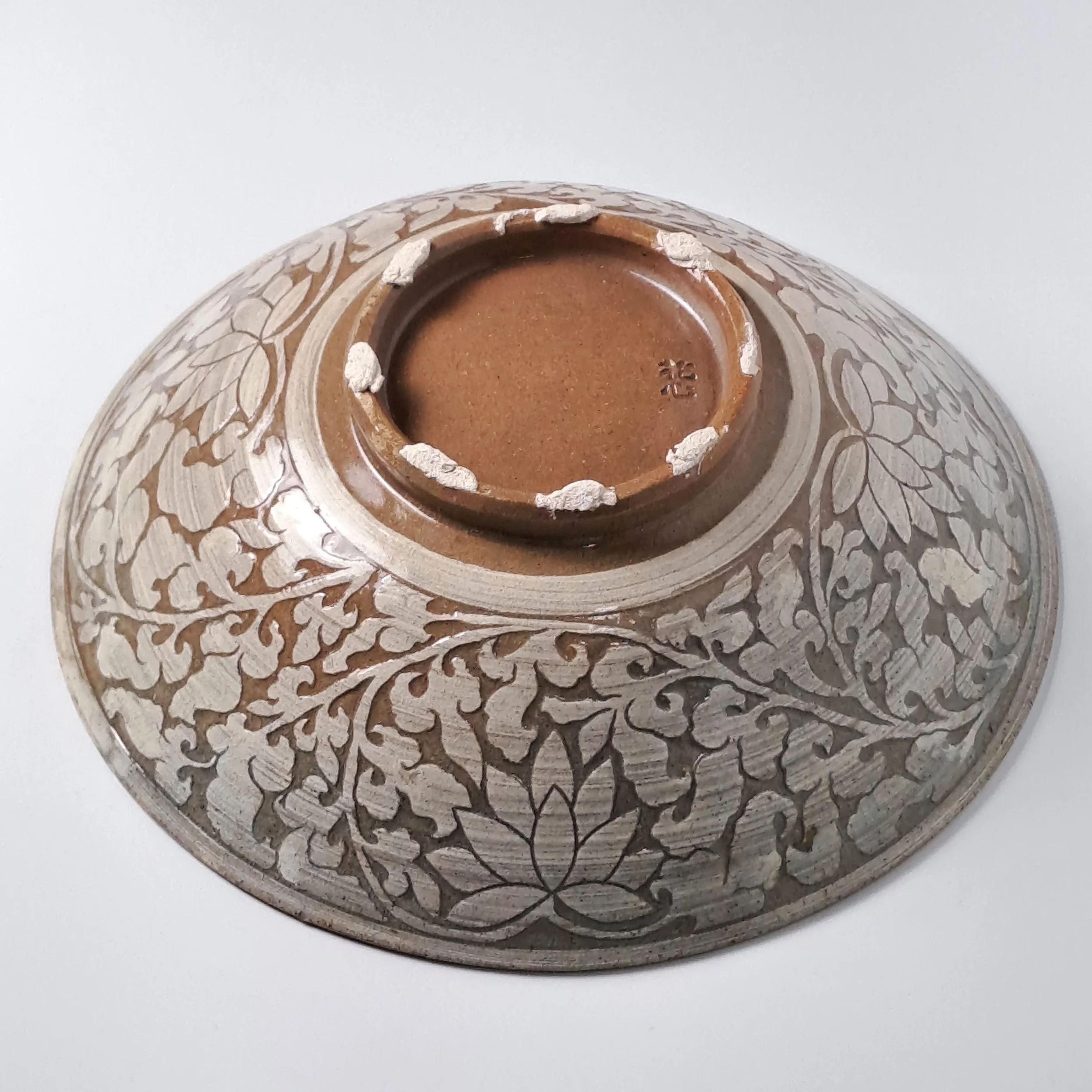 A grand Buncheong plate featuring lively incised fish on the interior and classic Goryeo lotus motifs on the exterior.